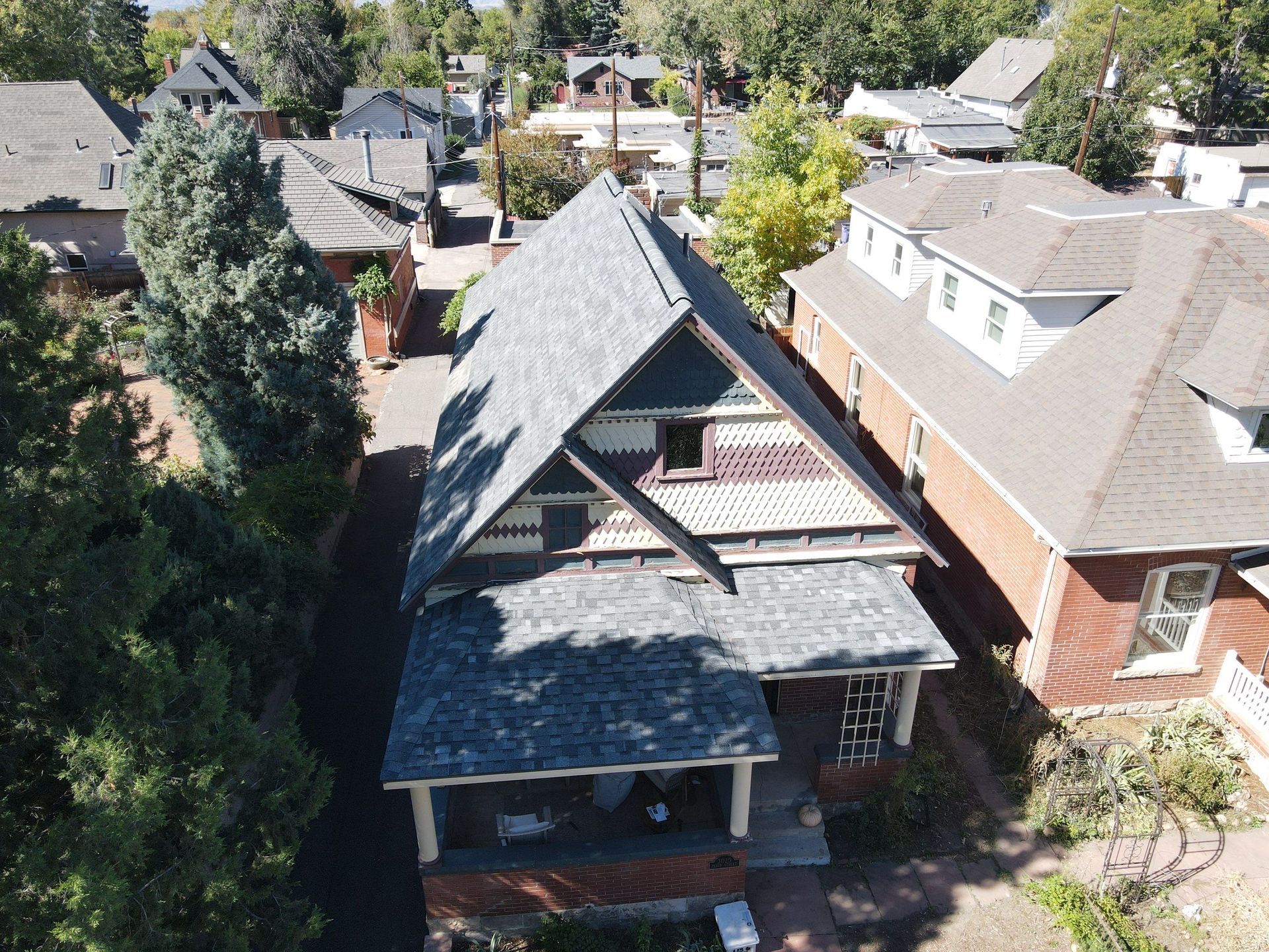 An aerial view of a house with a gray roof in a residential area.