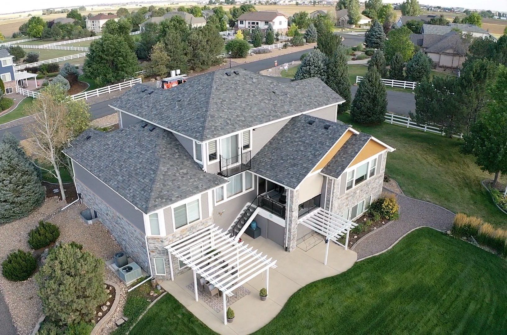 An aerial view of a large house with a pergola on the backyard.