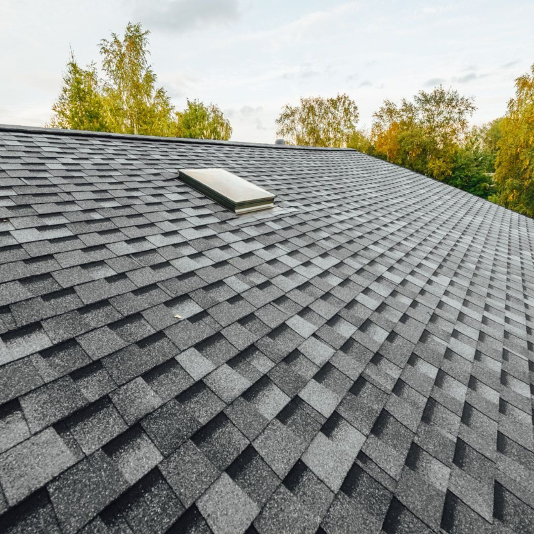 a close up of a roof with shingles and a skylight