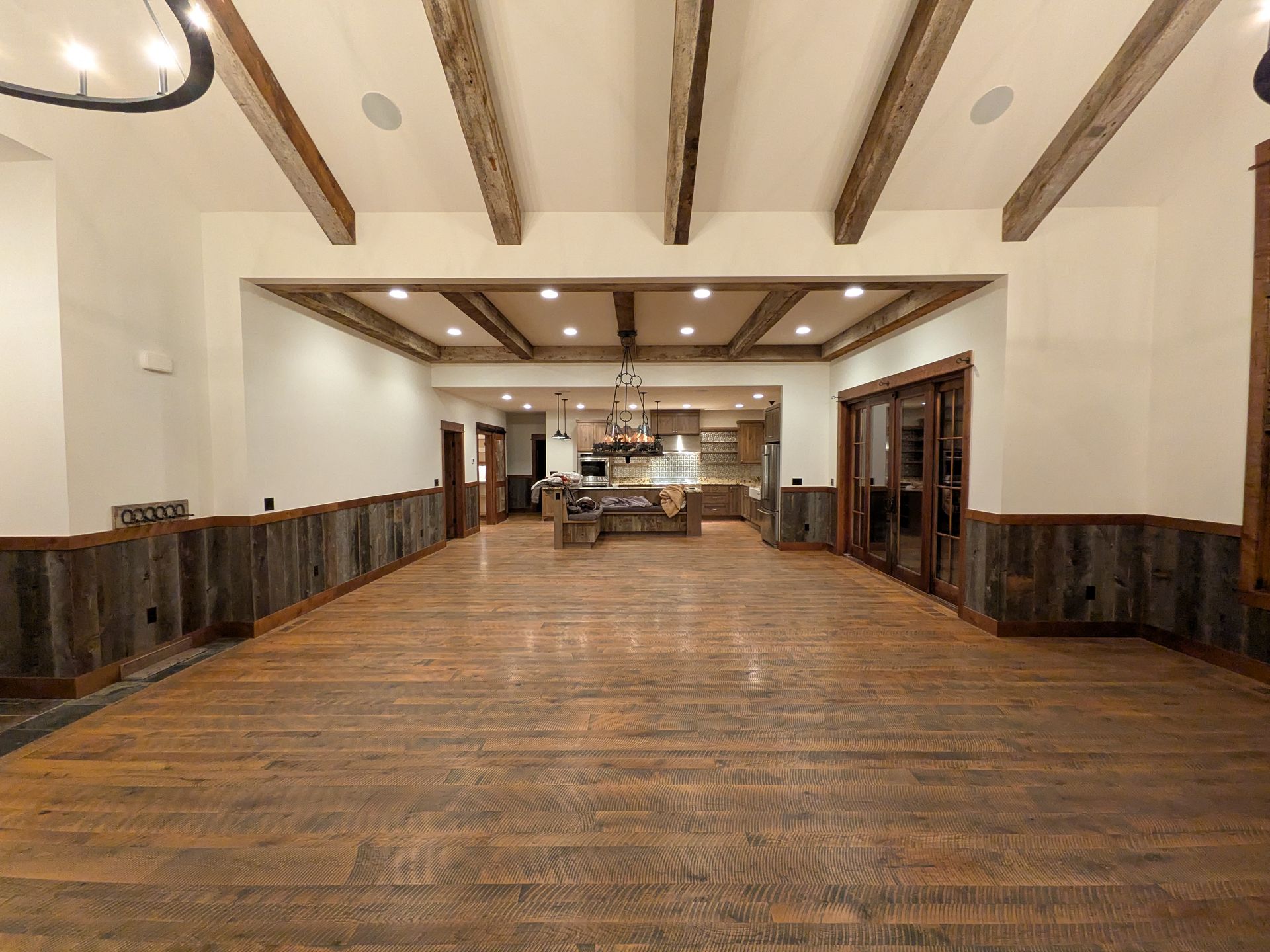 Empty rustic conference room with wood-paneled walls, exposed beams, and a long wooden table