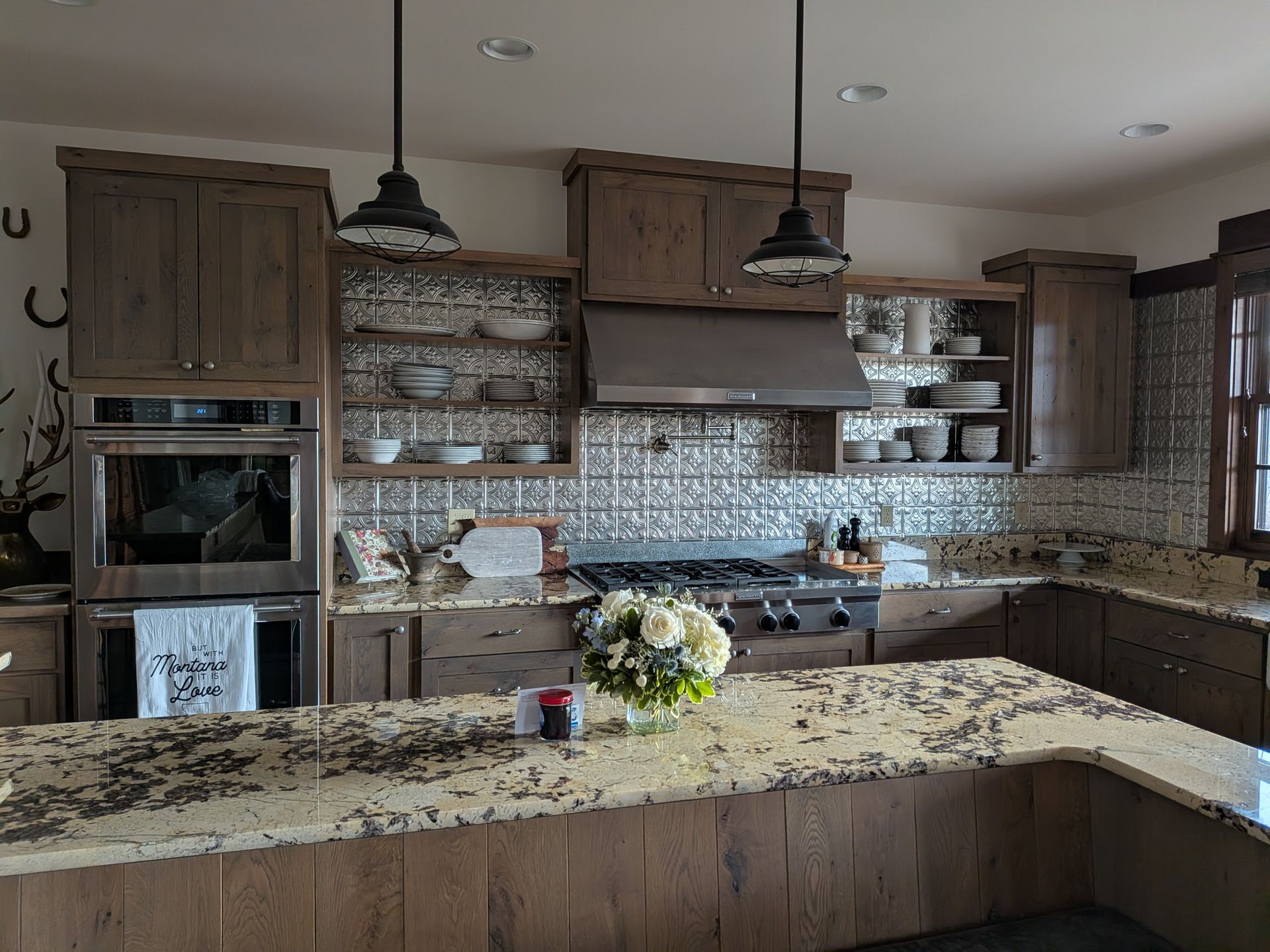 Modern kitchen with dark wood cabinets, granite island, and patterned tile backsplash