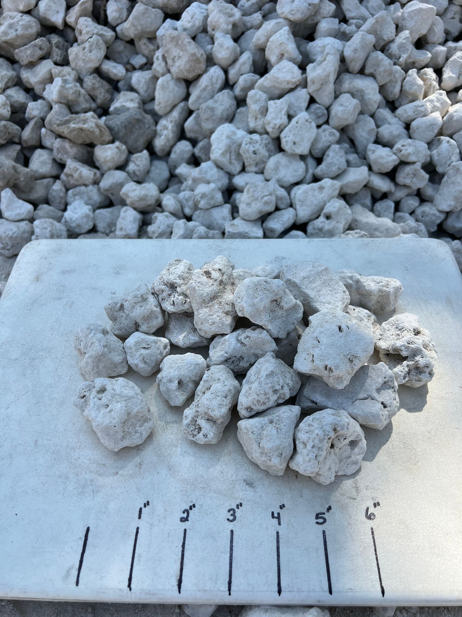 A pile of #4 Limestone sits next to a pile of smaller rocks