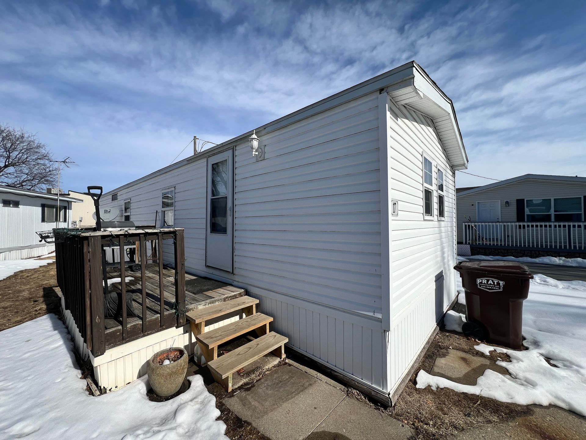 Spacious, modern interior with kitchen island, dark cabinets, and wood-look flooring.