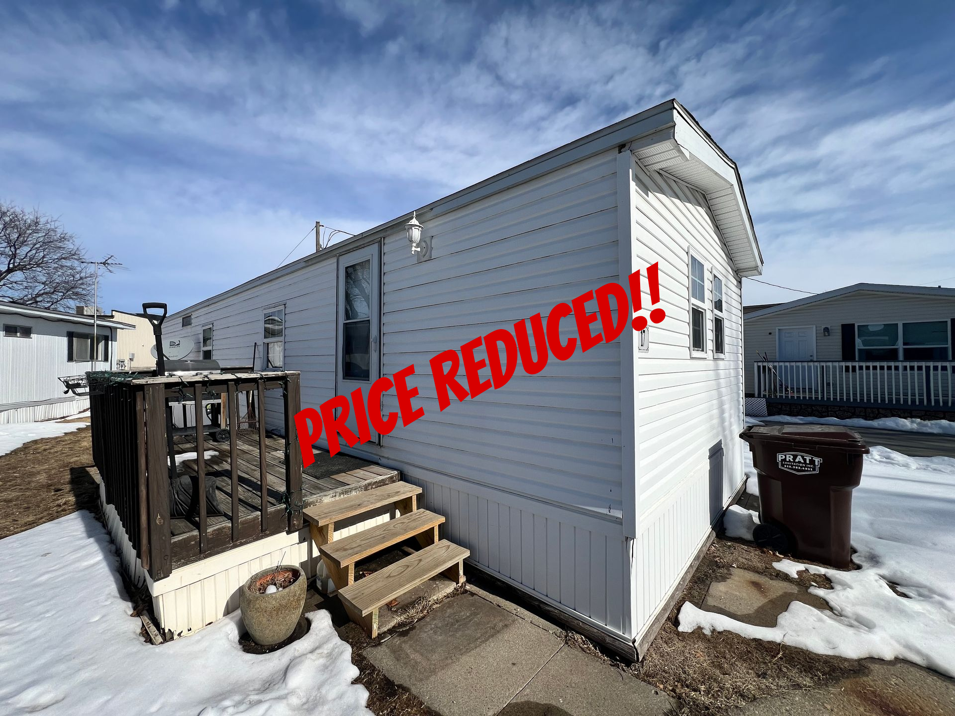 Spacious, modern interior with kitchen island, dark cabinets, and wood-look flooring.