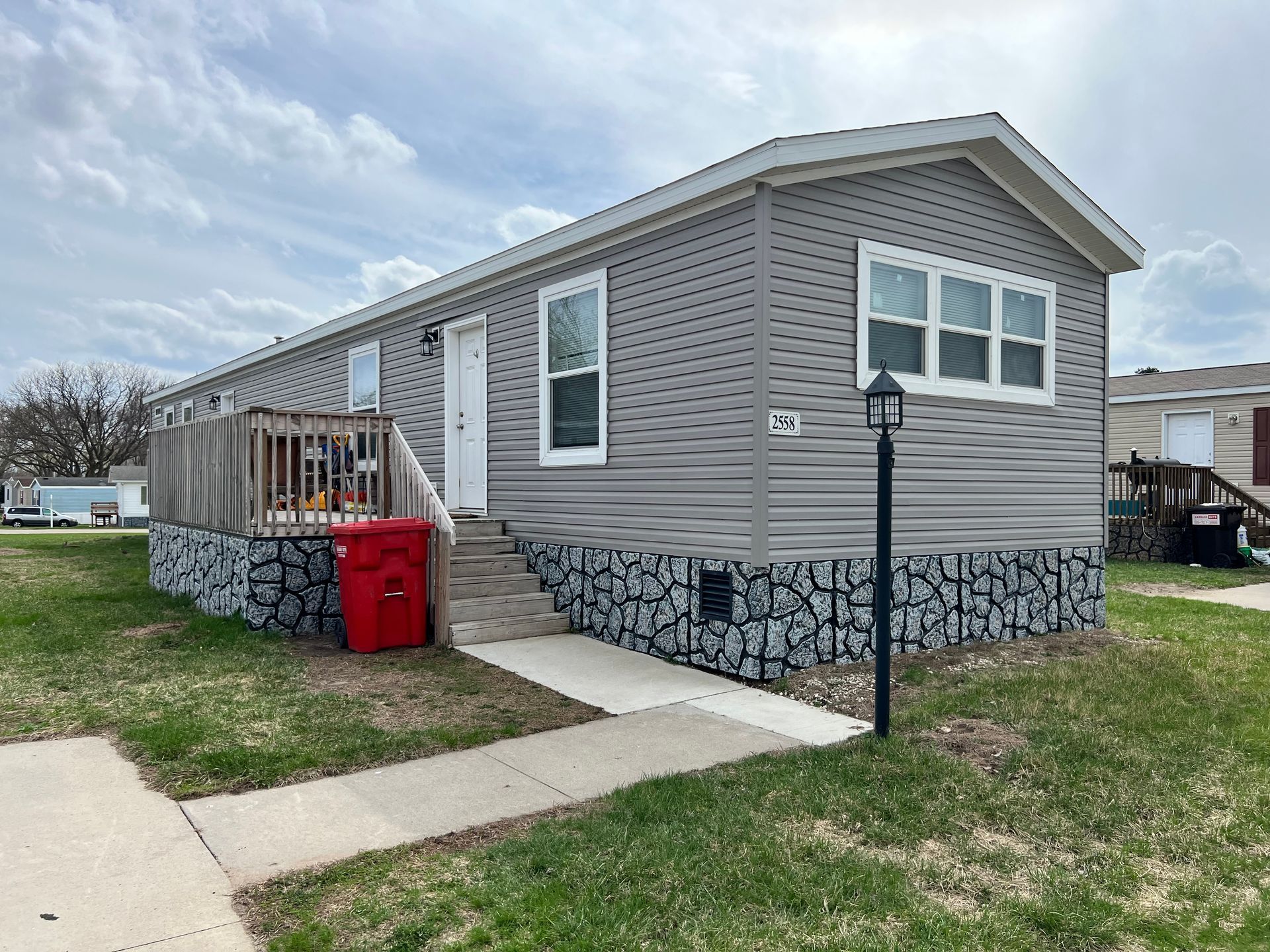 House with a covered porch and detached garage on a sunny day.