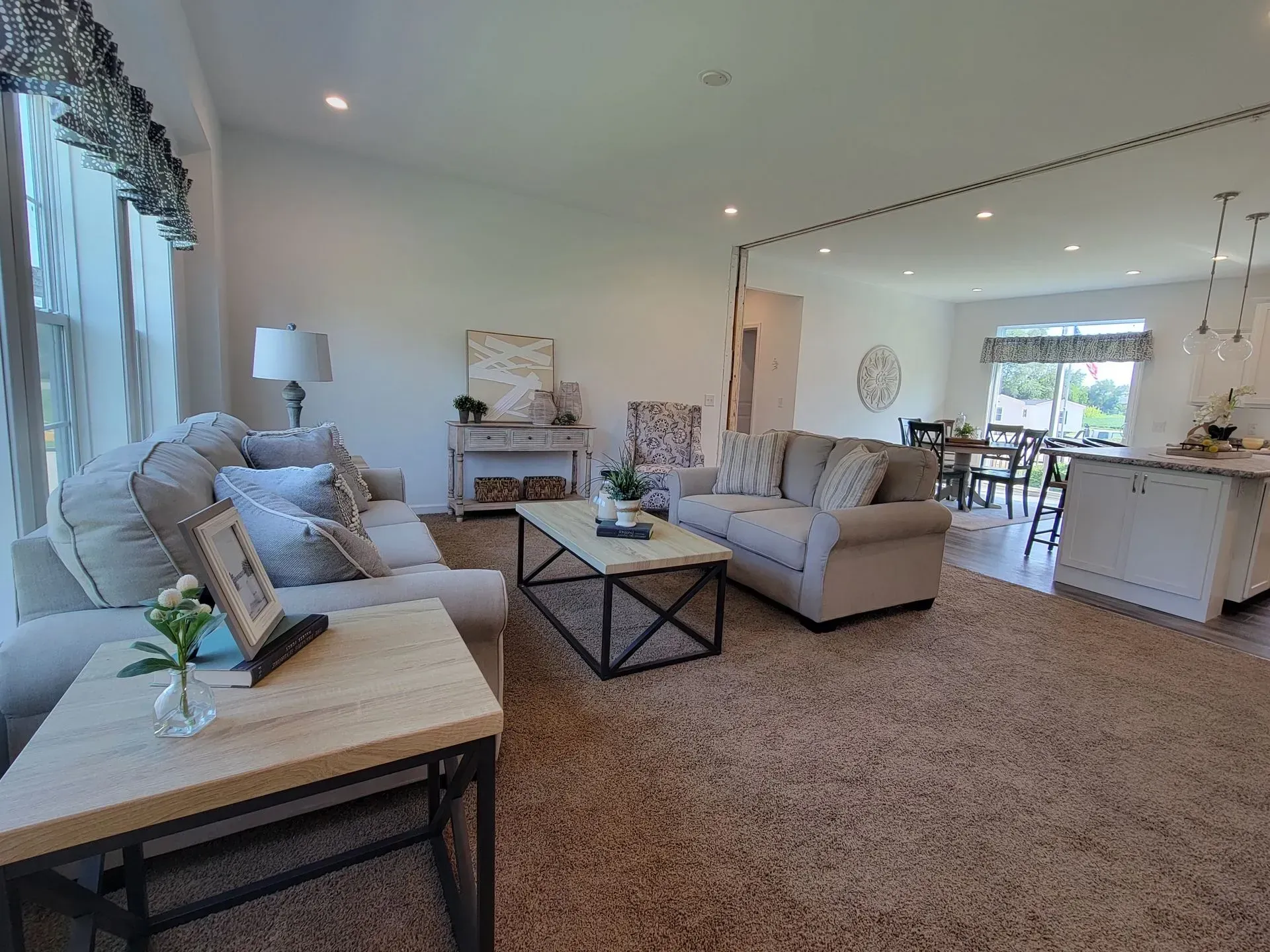 Living room with two sofas, coffee table, rug, and access to a dining area.