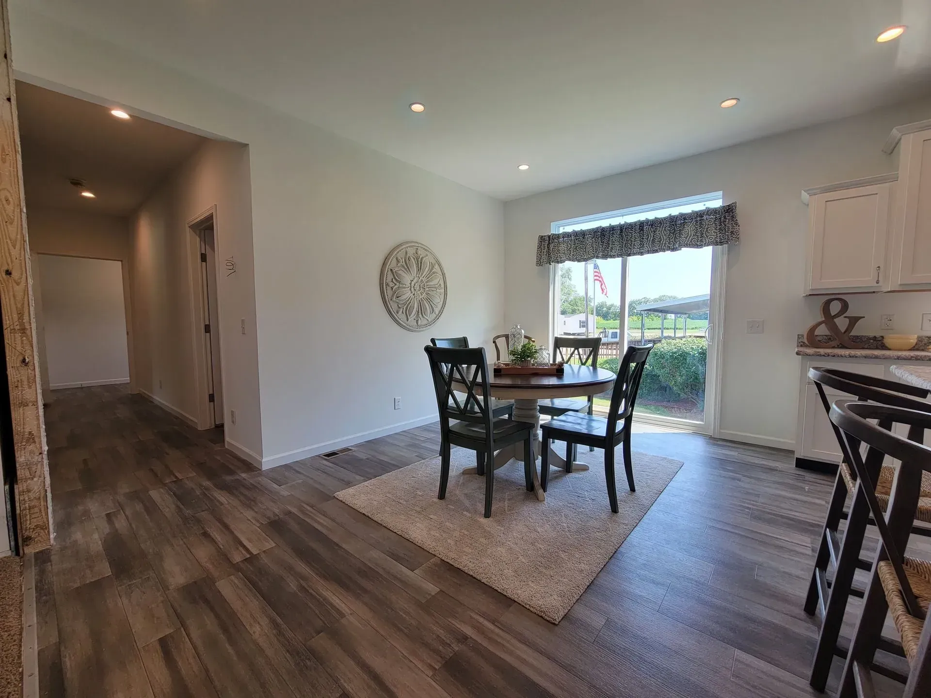 Dining room with a table and chairs, rug, and window with a view.