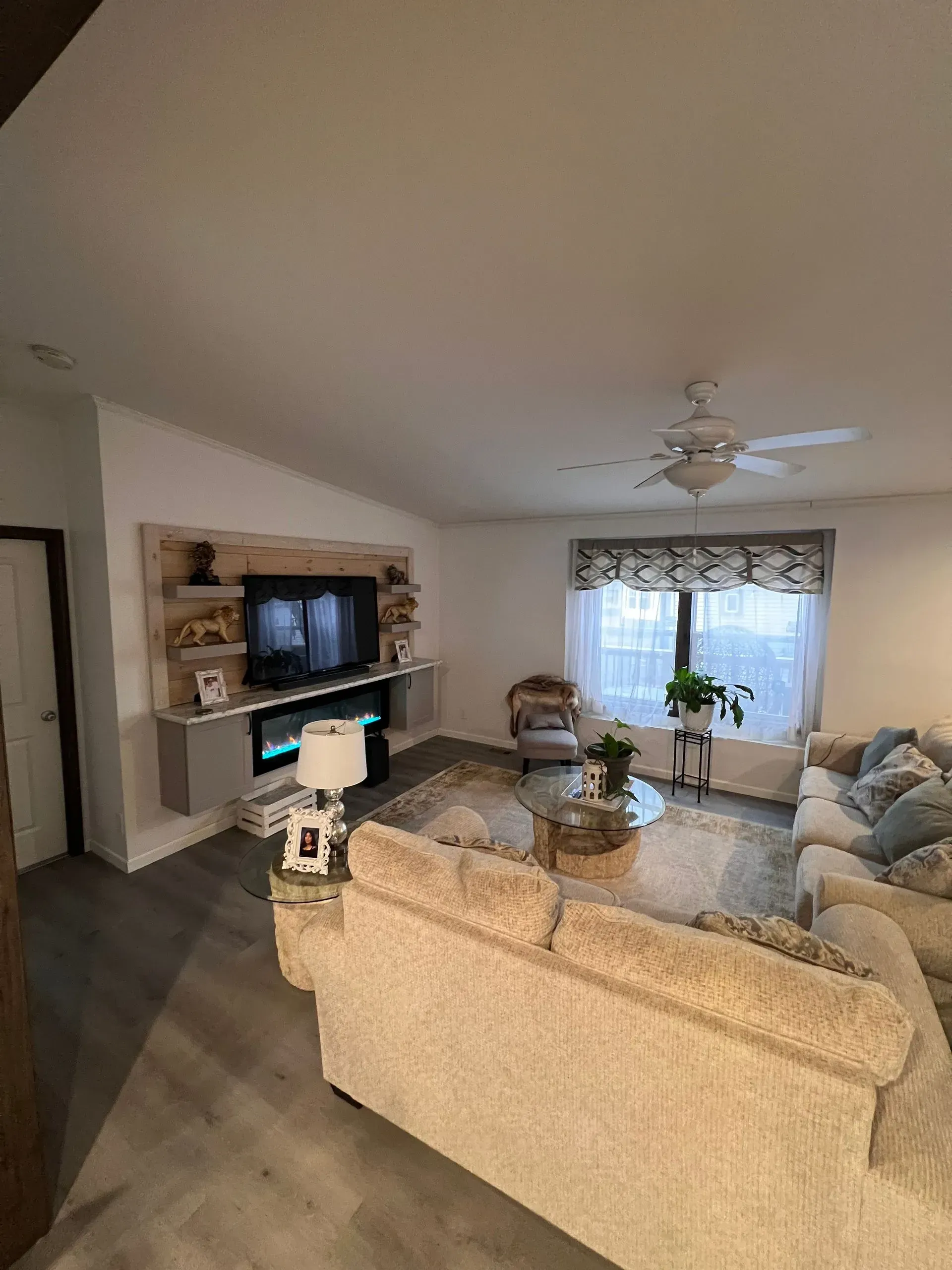 Living room with a built-in fireplace, TV, and light-colored sofa.