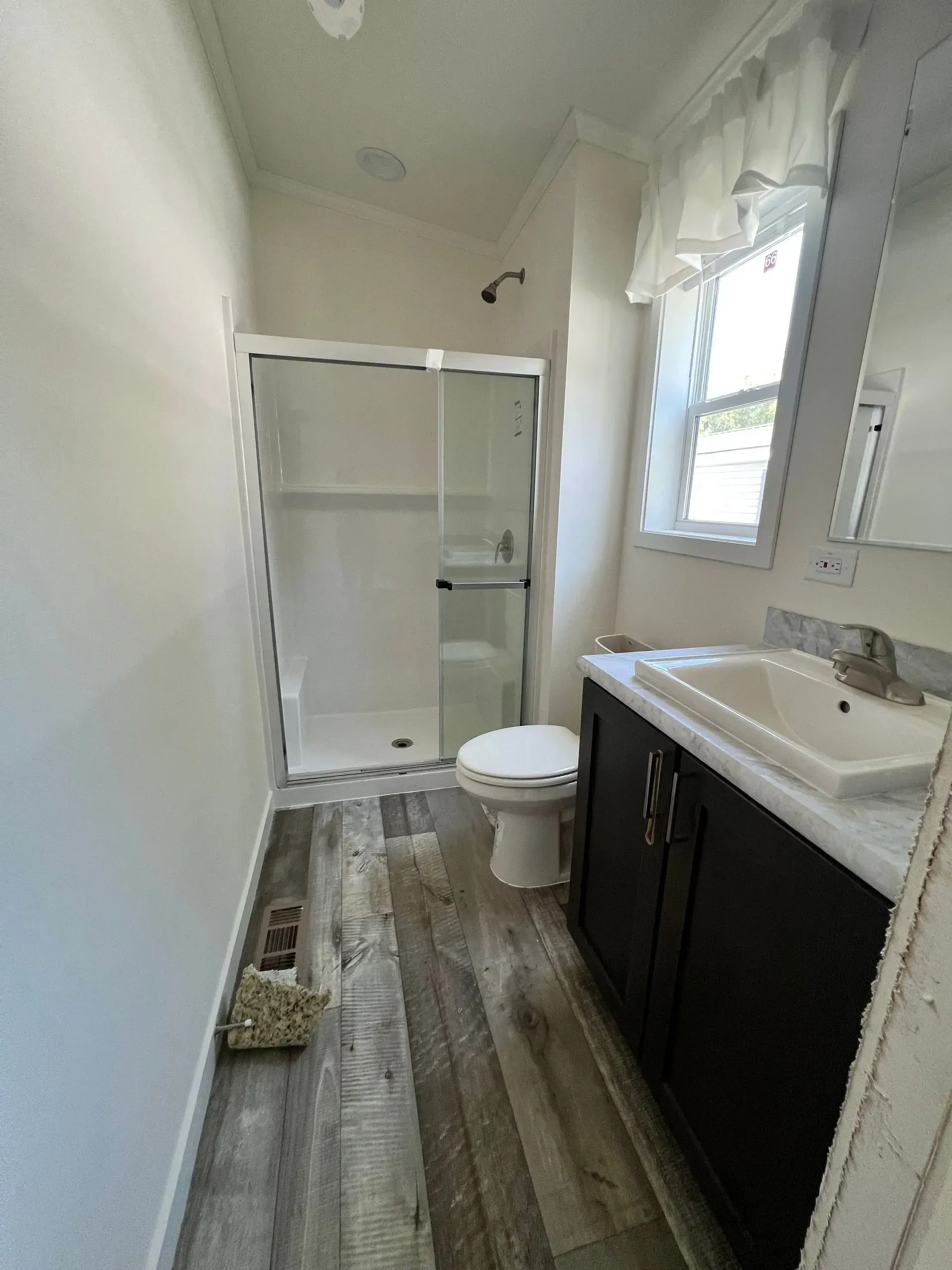 Bathroom with shower, toilet, and vanity with dark cabinets and a white countertop.