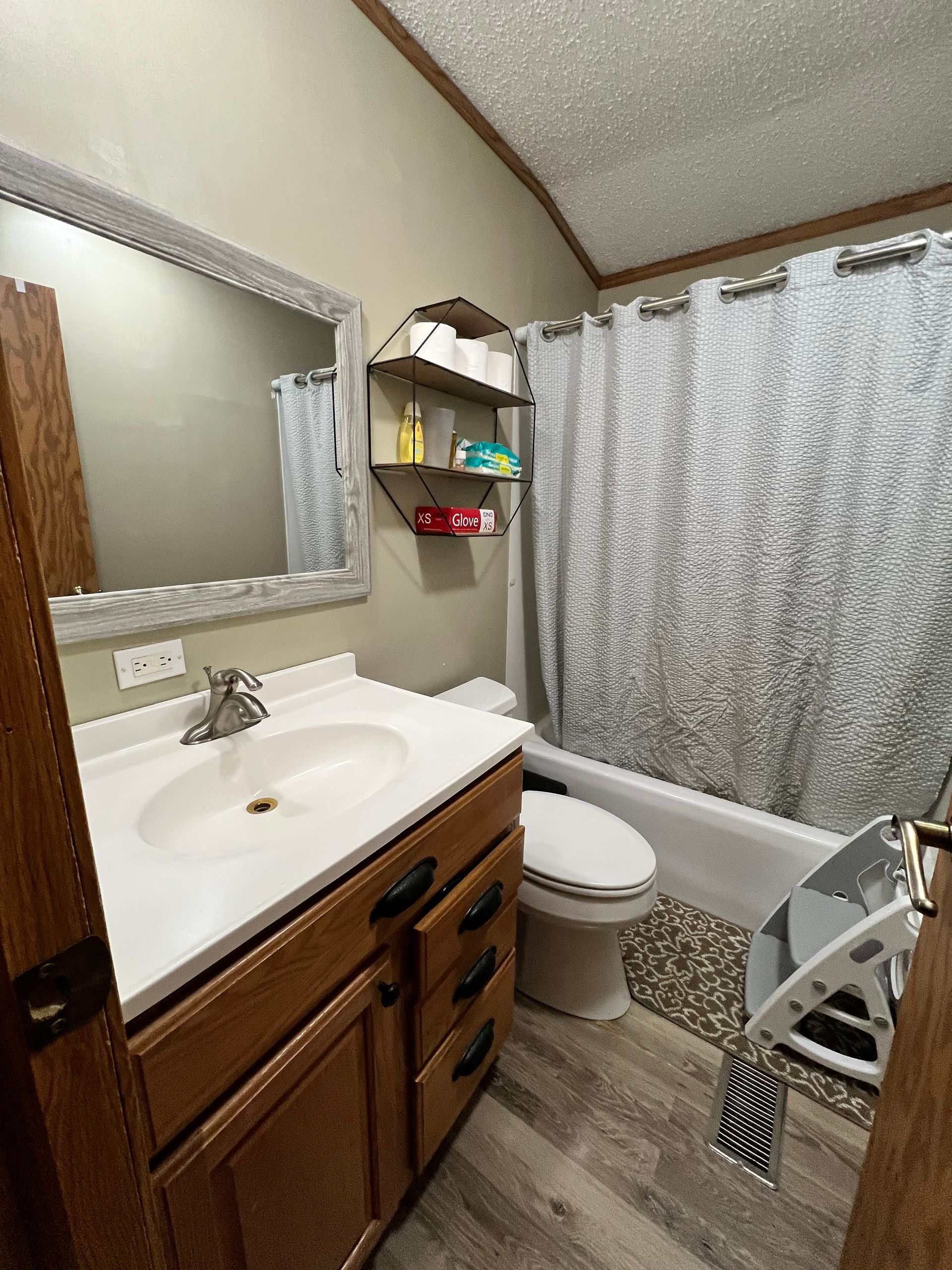 Bathroom interior with a vanity, toilet, and bathtub with a shower curtain.