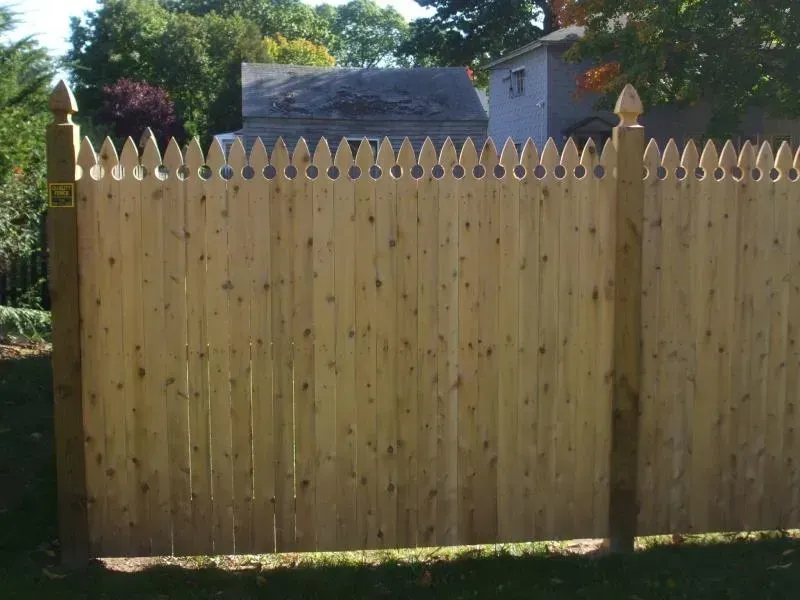 A wooden fence with a house in the background