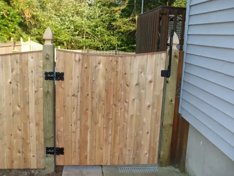 A wooden fence with a gate in front of a house