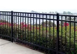 A black metal fence with a view of a body of water behind it.