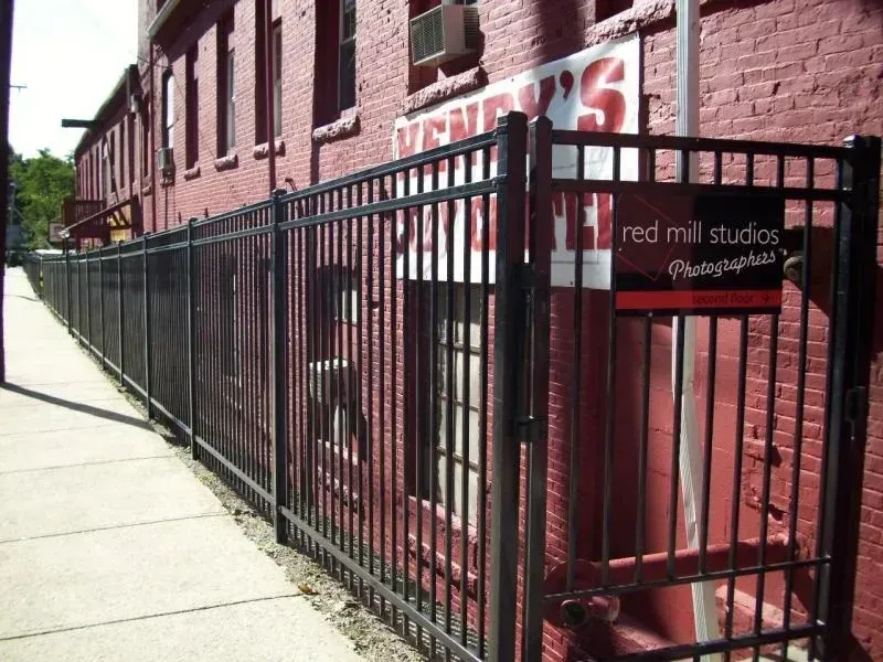 A fence with a sign that says red mill studios