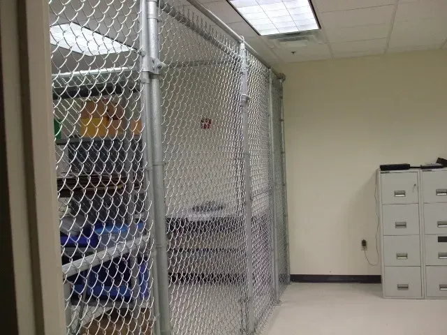 A room with a chain link fence and filing cabinets