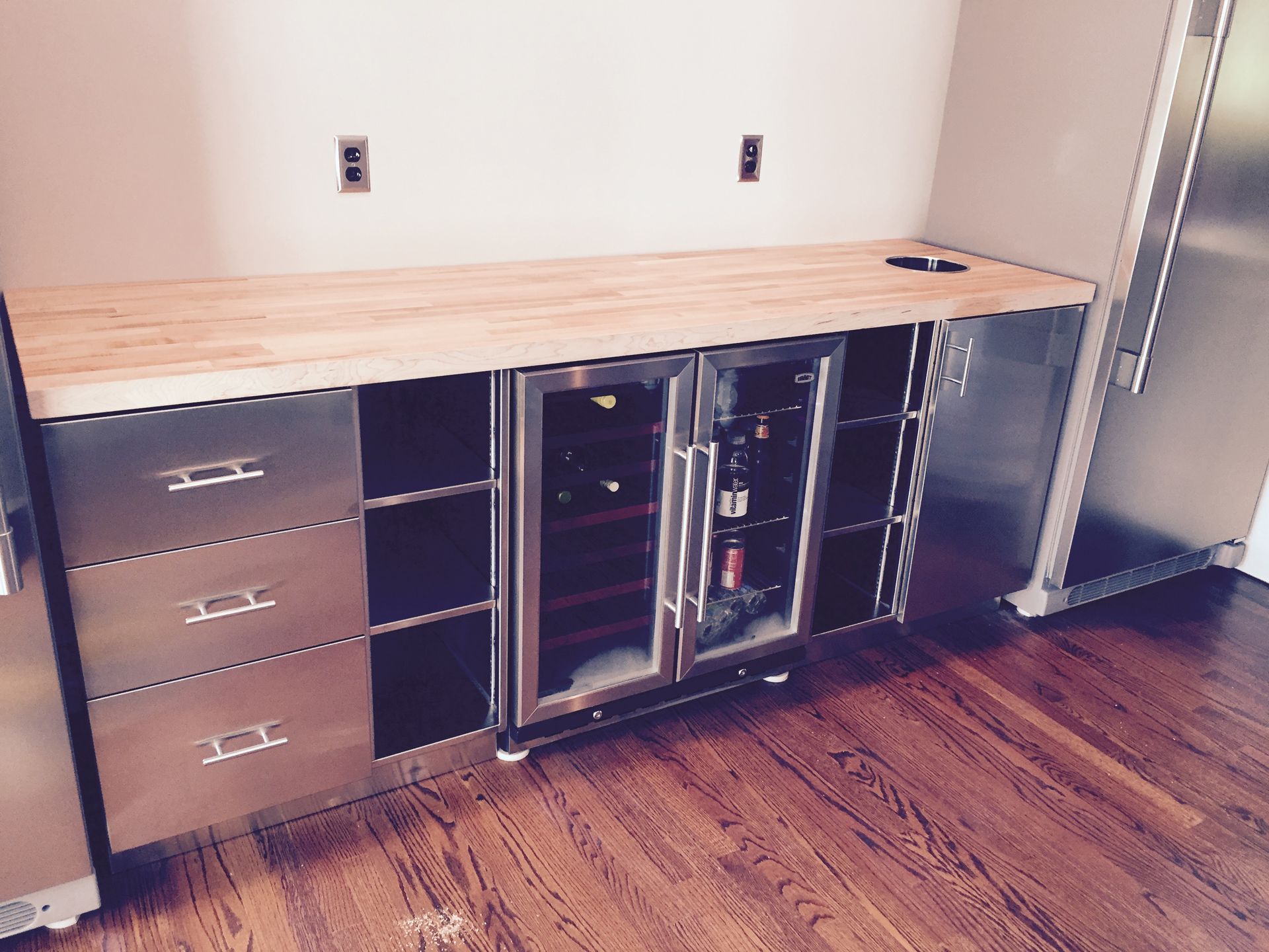 A kitchen with stainless steel cabinets and wooden counter tops