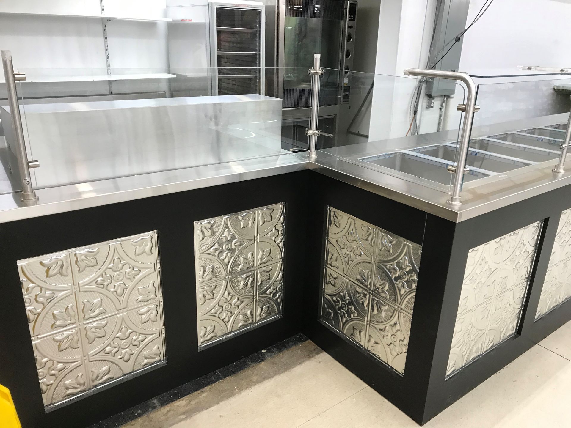 A kitchen with a stainless steel counter top and a black counter top.