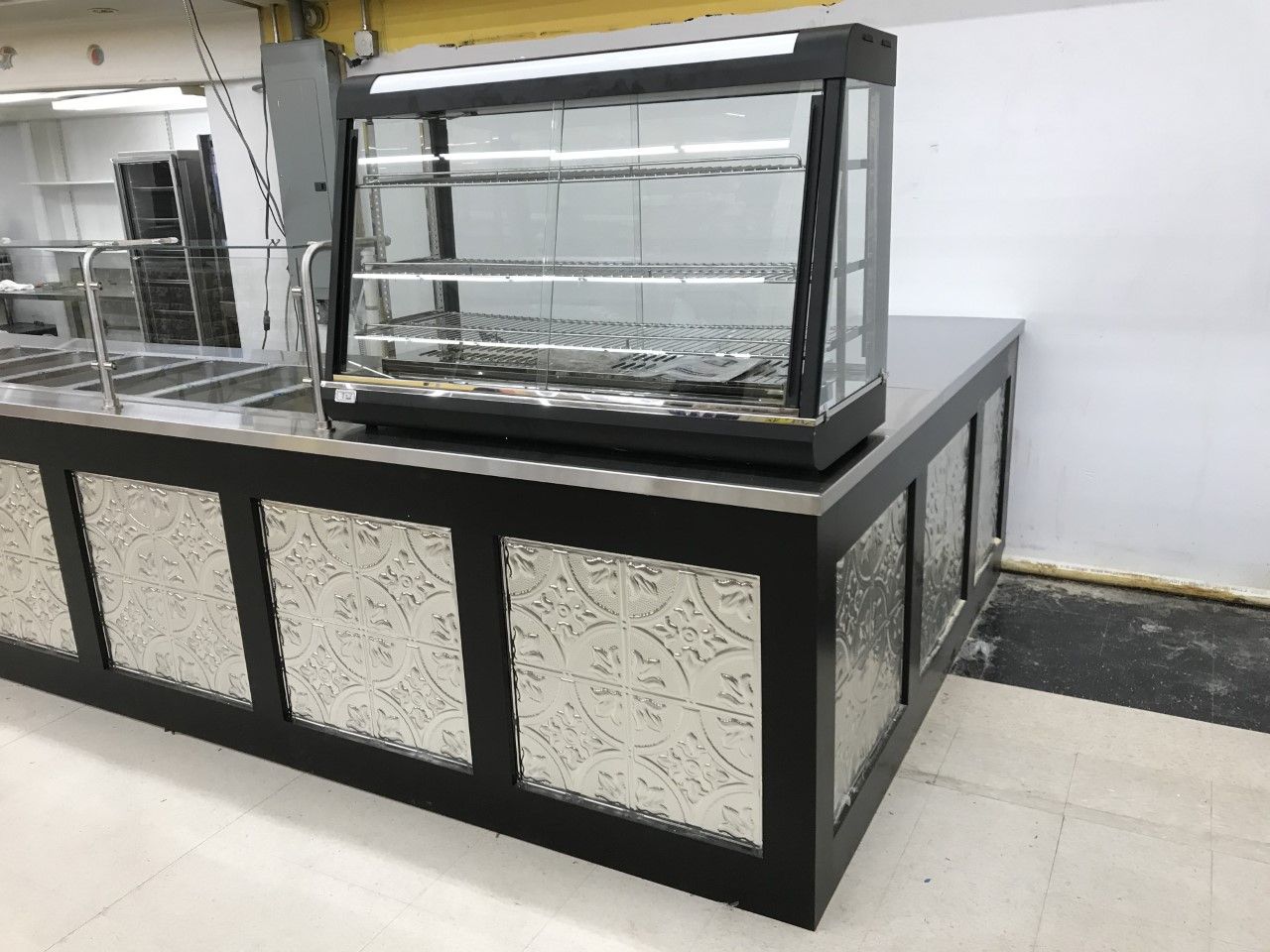 A display case is sitting on top of a counter in a kitchen.