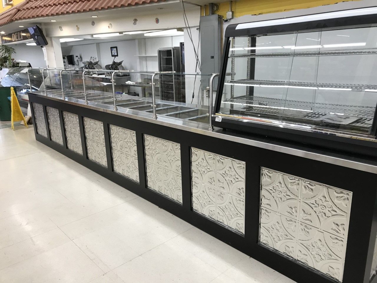 A long counter with a glass display case in a restaurant.