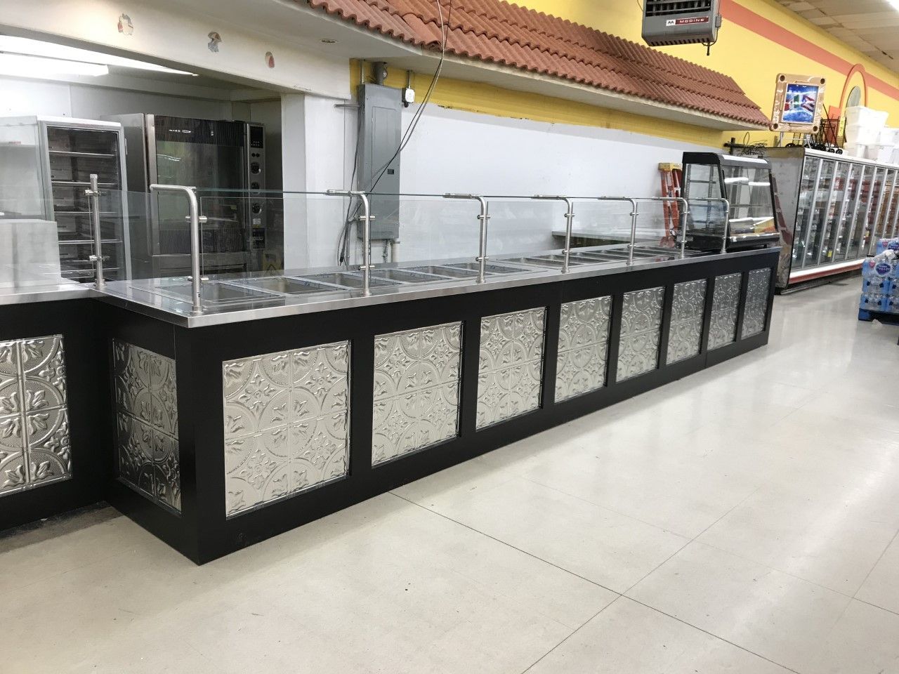 There is a long counter in the middle of a store.