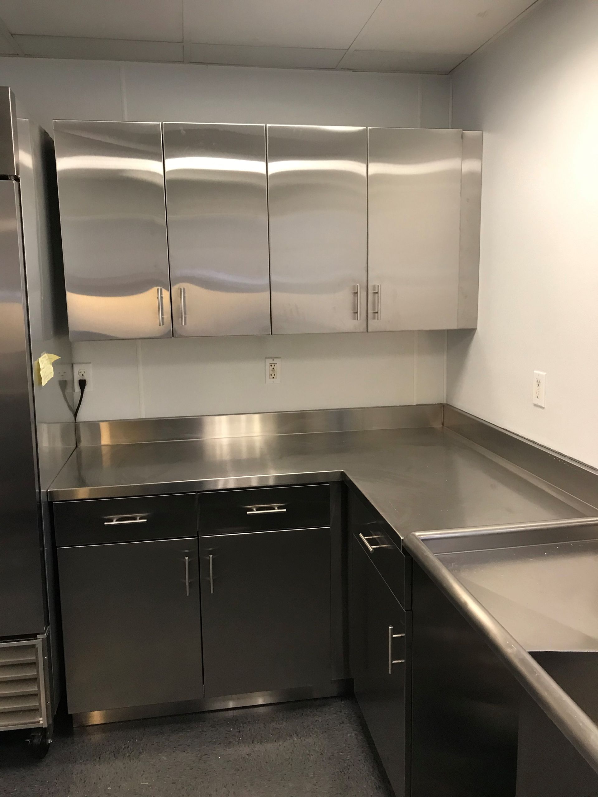 A kitchen with stainless steel cabinets and counter tops