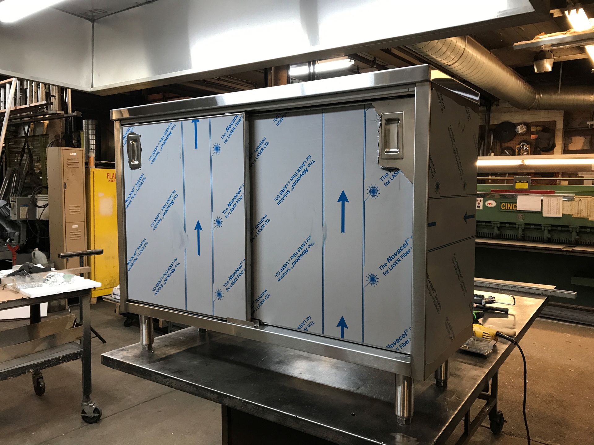 A stainless steel cabinet is sitting on top of a table.