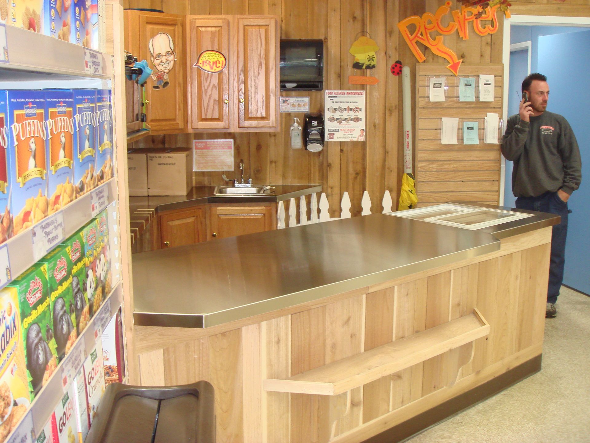 A man talking on a cell phone in front of a counter in a store