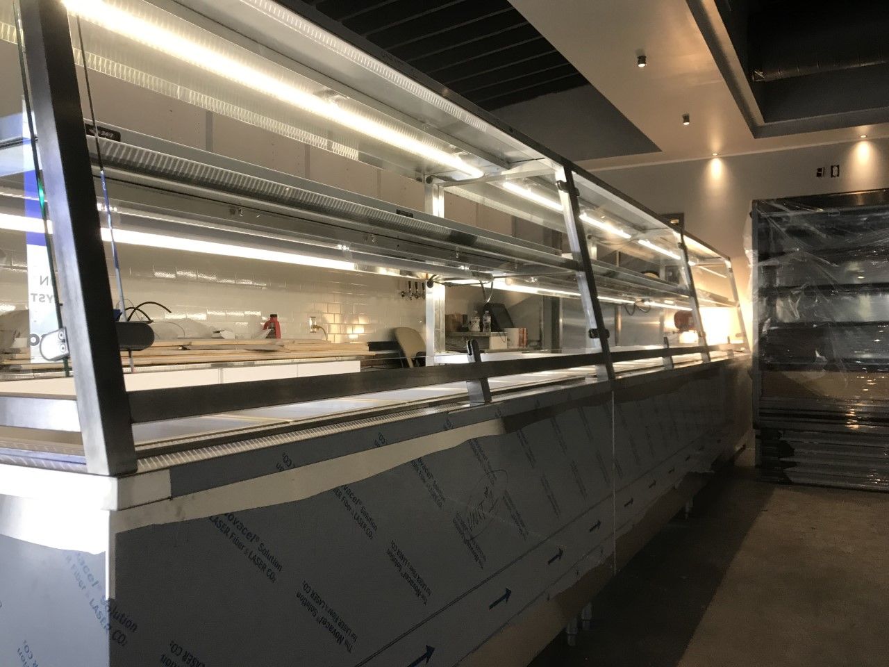 A long display case in a restaurant with a lot of lights on it.