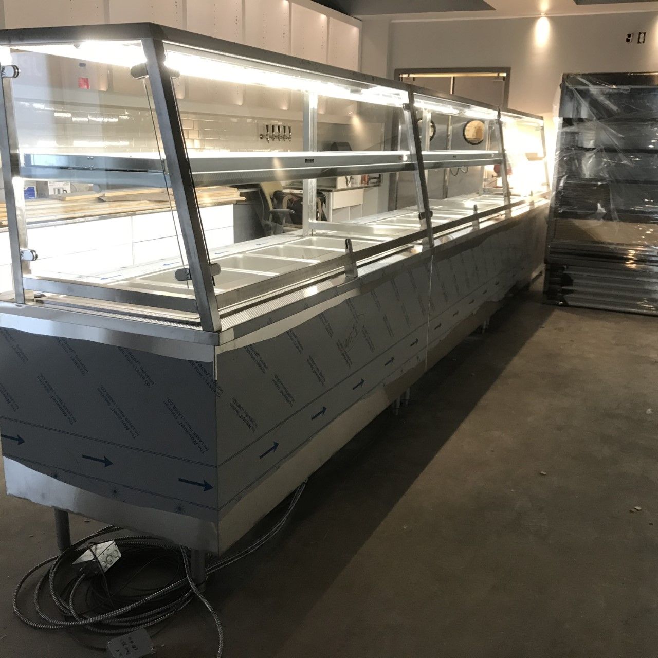 A stainless steel display case is sitting in a warehouse