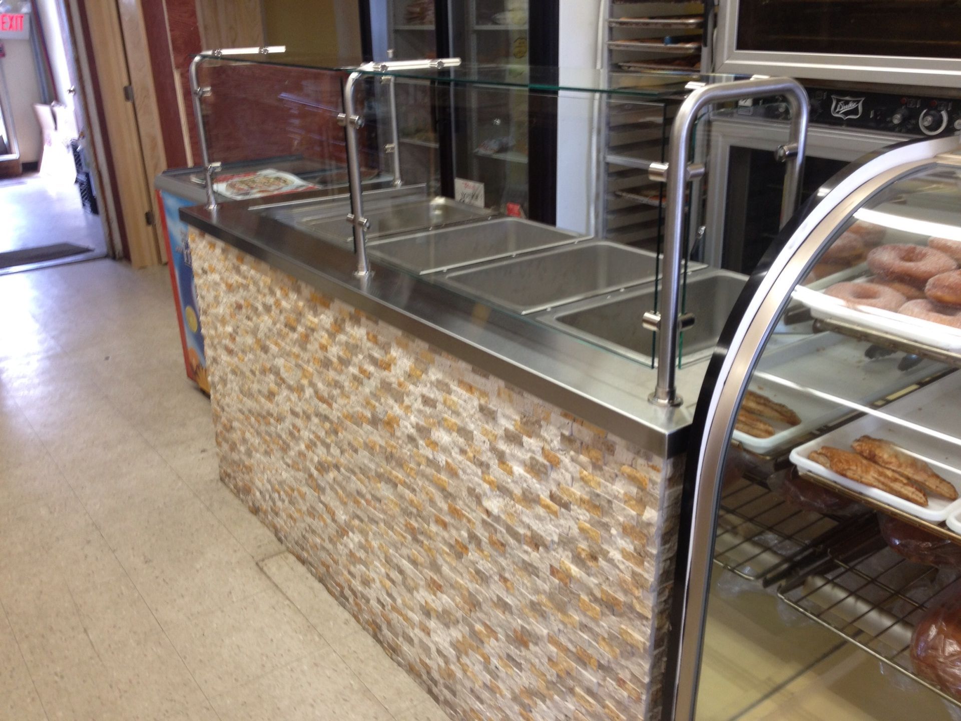 A bakery with a stainless steel counter and a glass display case