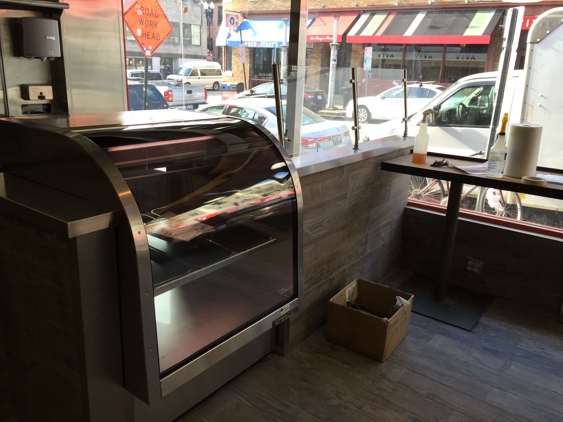 A display case in a restaurant with a cardboard box in front of it