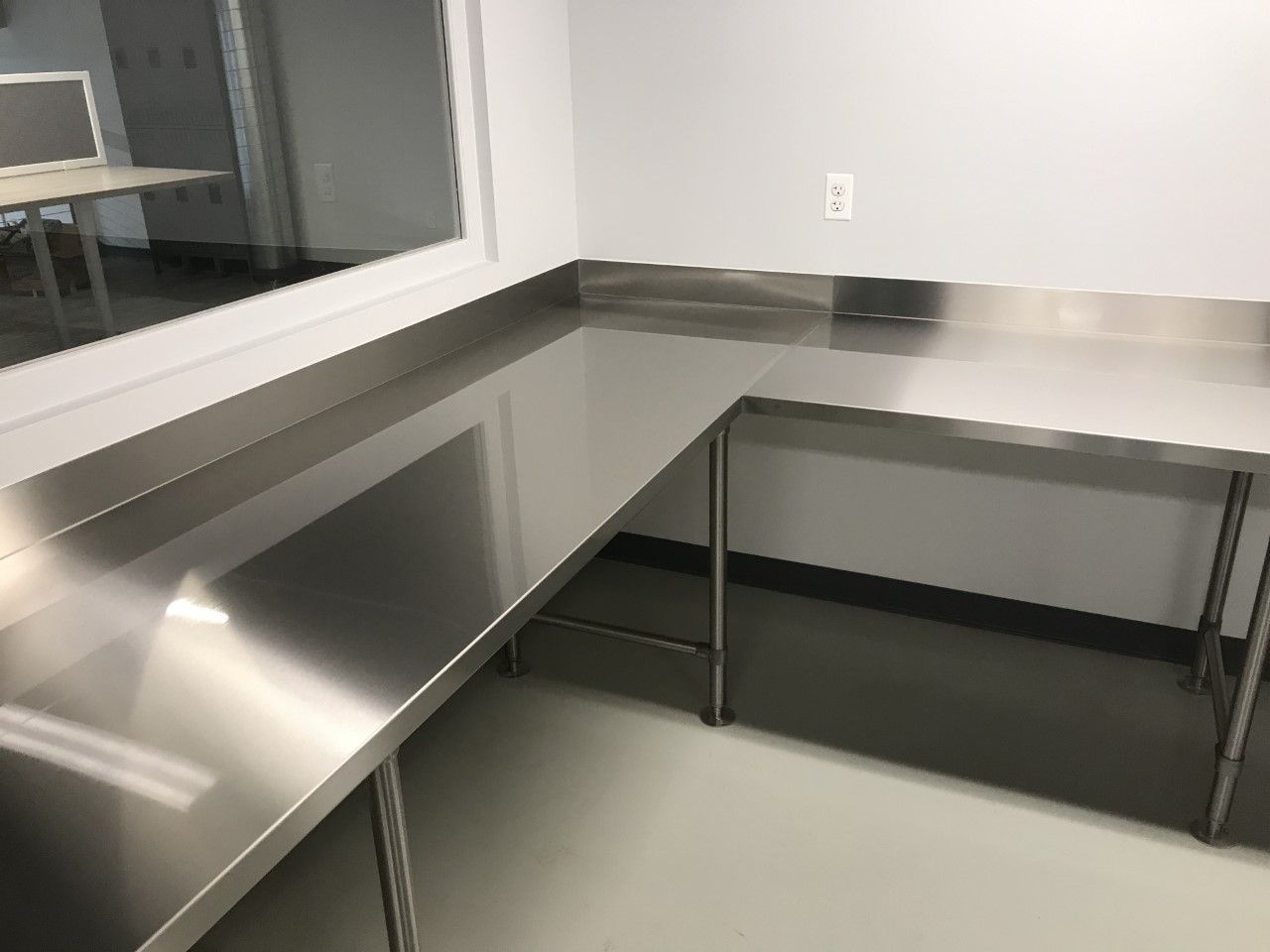 A room with stainless steel tables and a window.