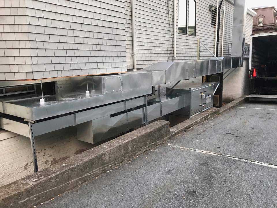 A large metal pipe is attached to the side of a building.