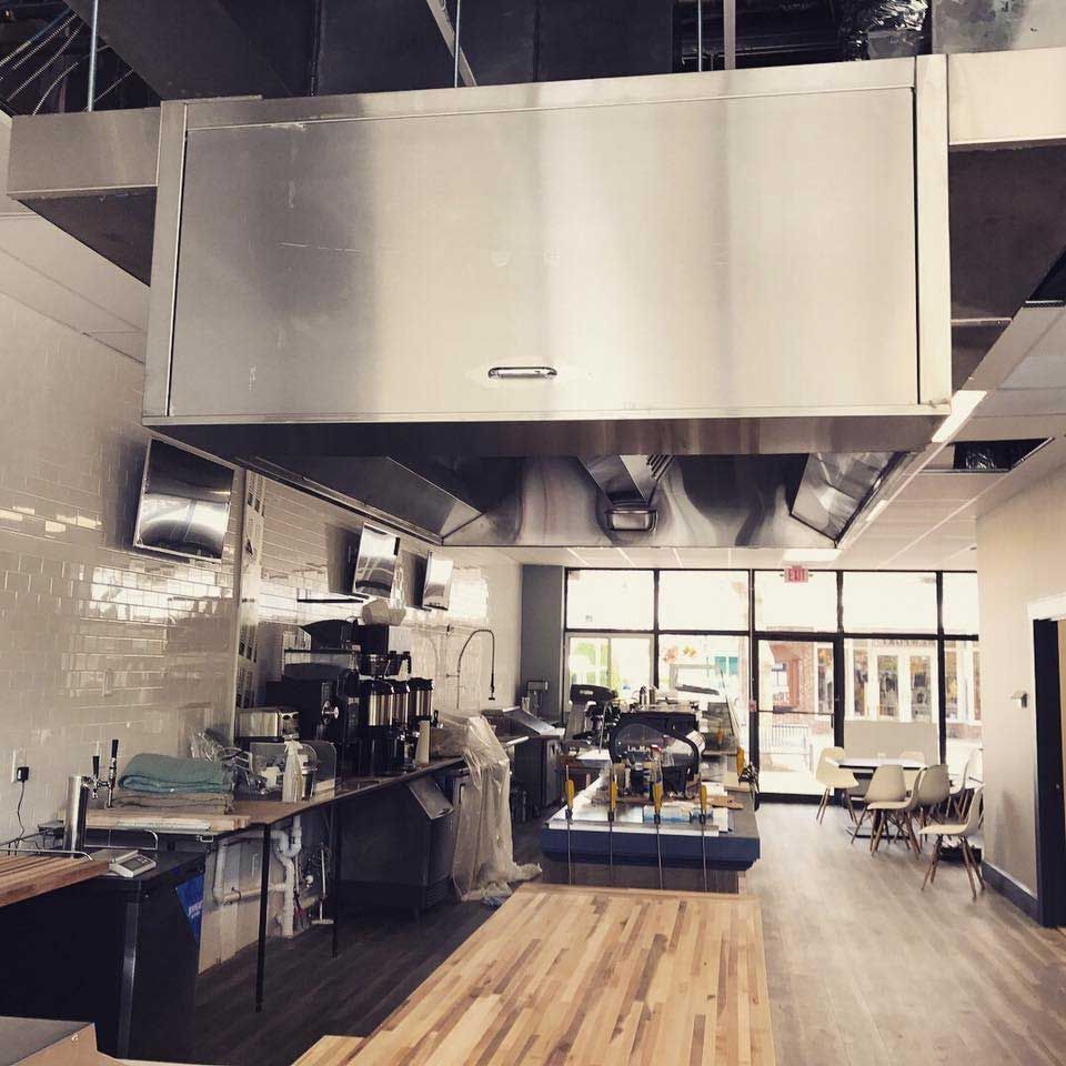 A kitchen with stainless steel appliances and wooden floors