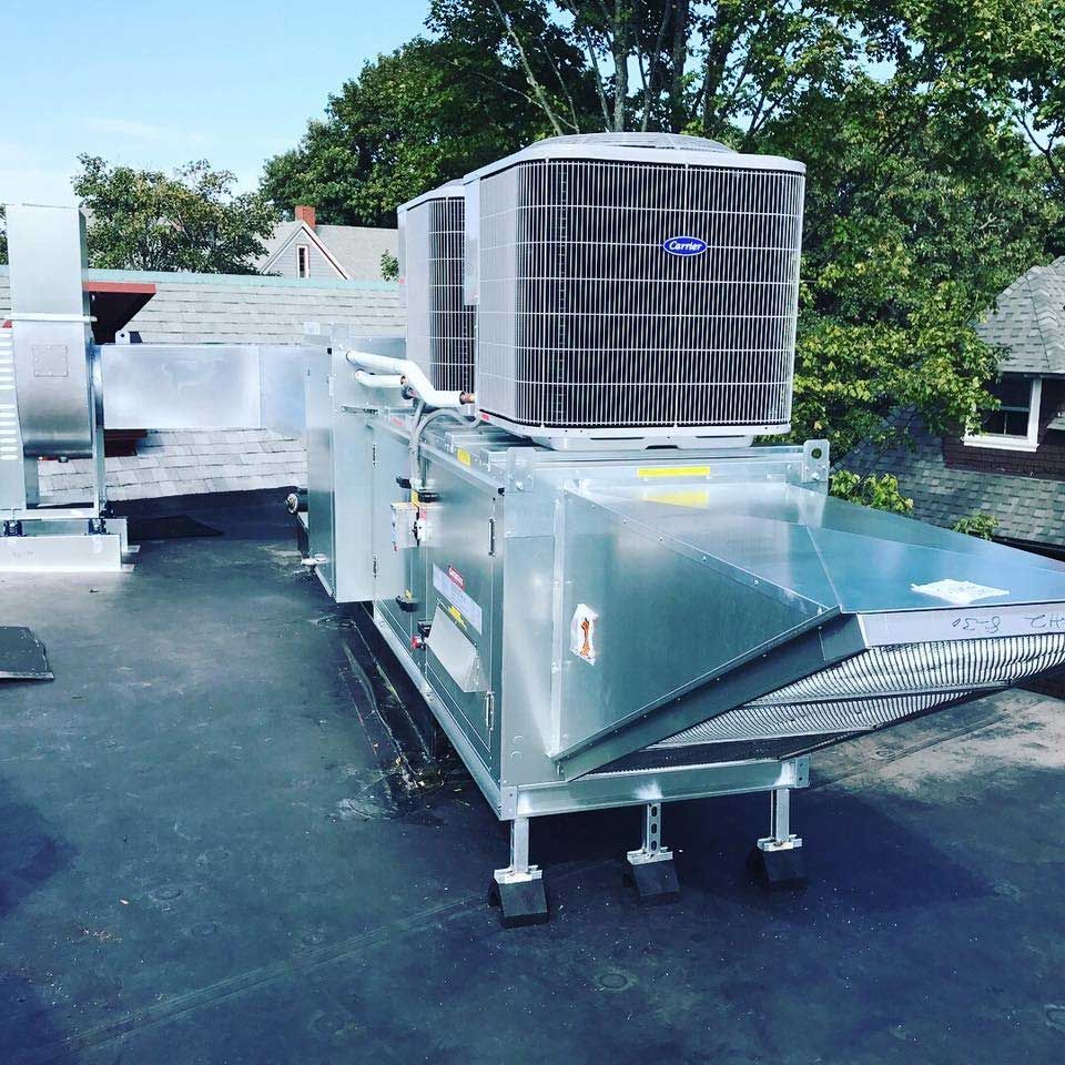 A large air conditioner is sitting on top of a roof.