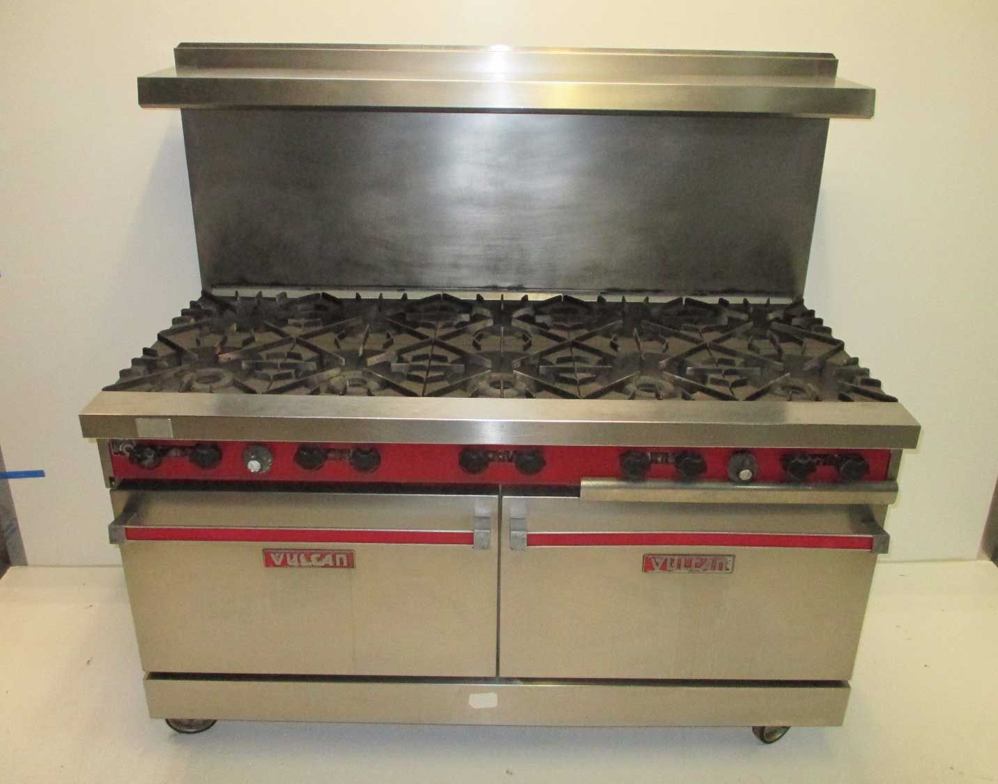 A stainless steel stove top oven with a red trim