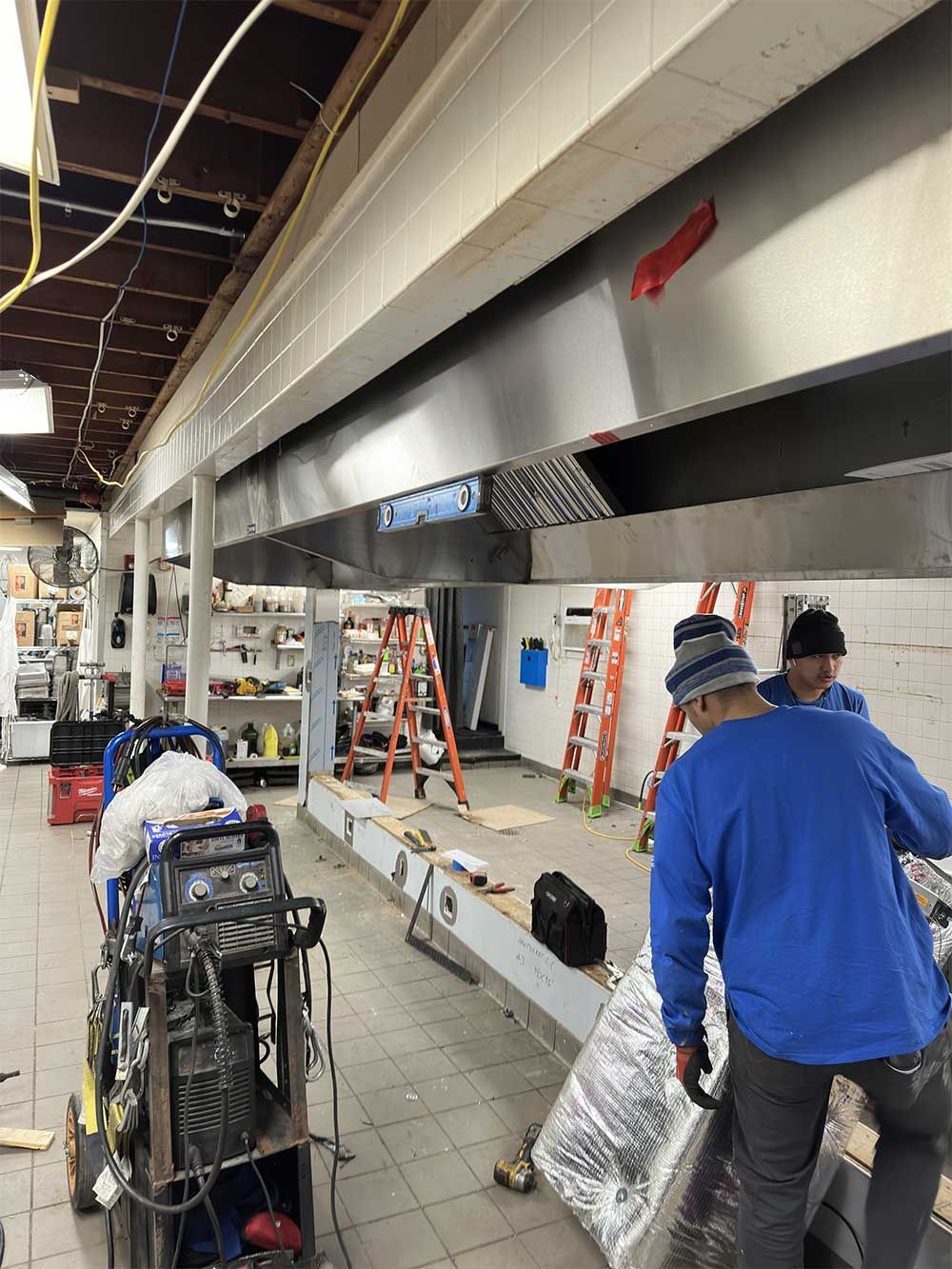 A group of men are working in a kitchen under construction.