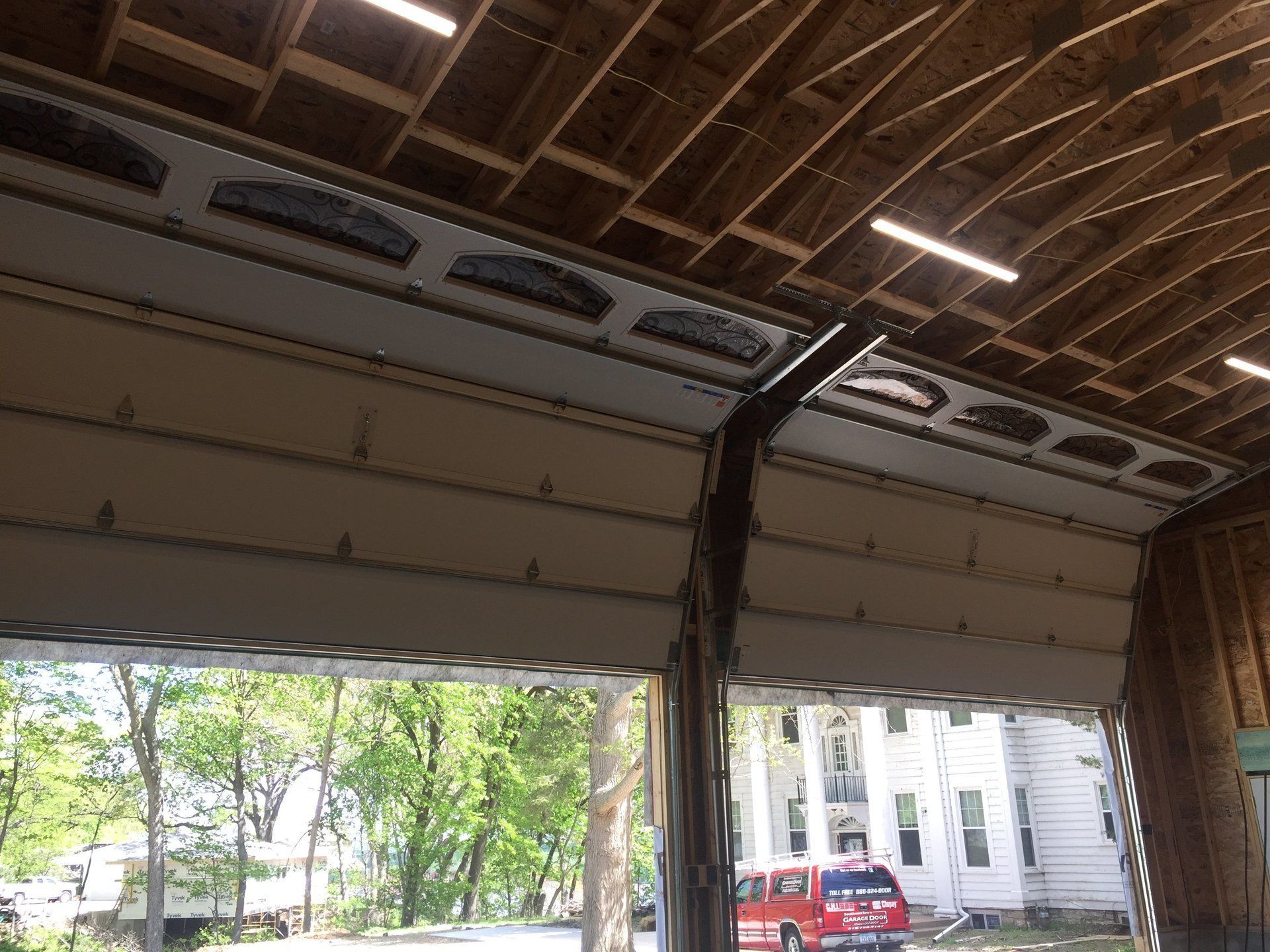 A red van is parked in a garage with the door open.