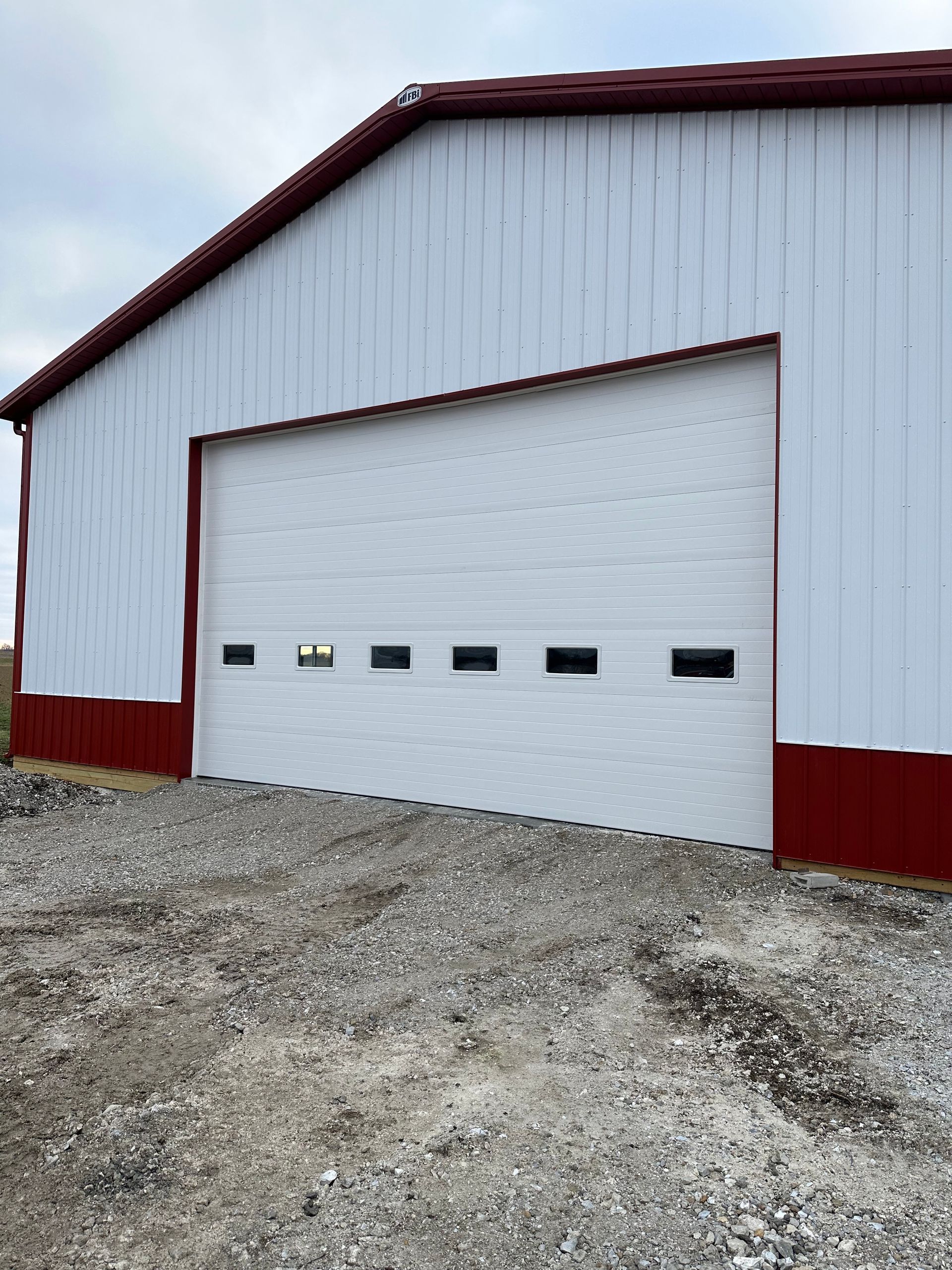 A white and red building with a large garage door.