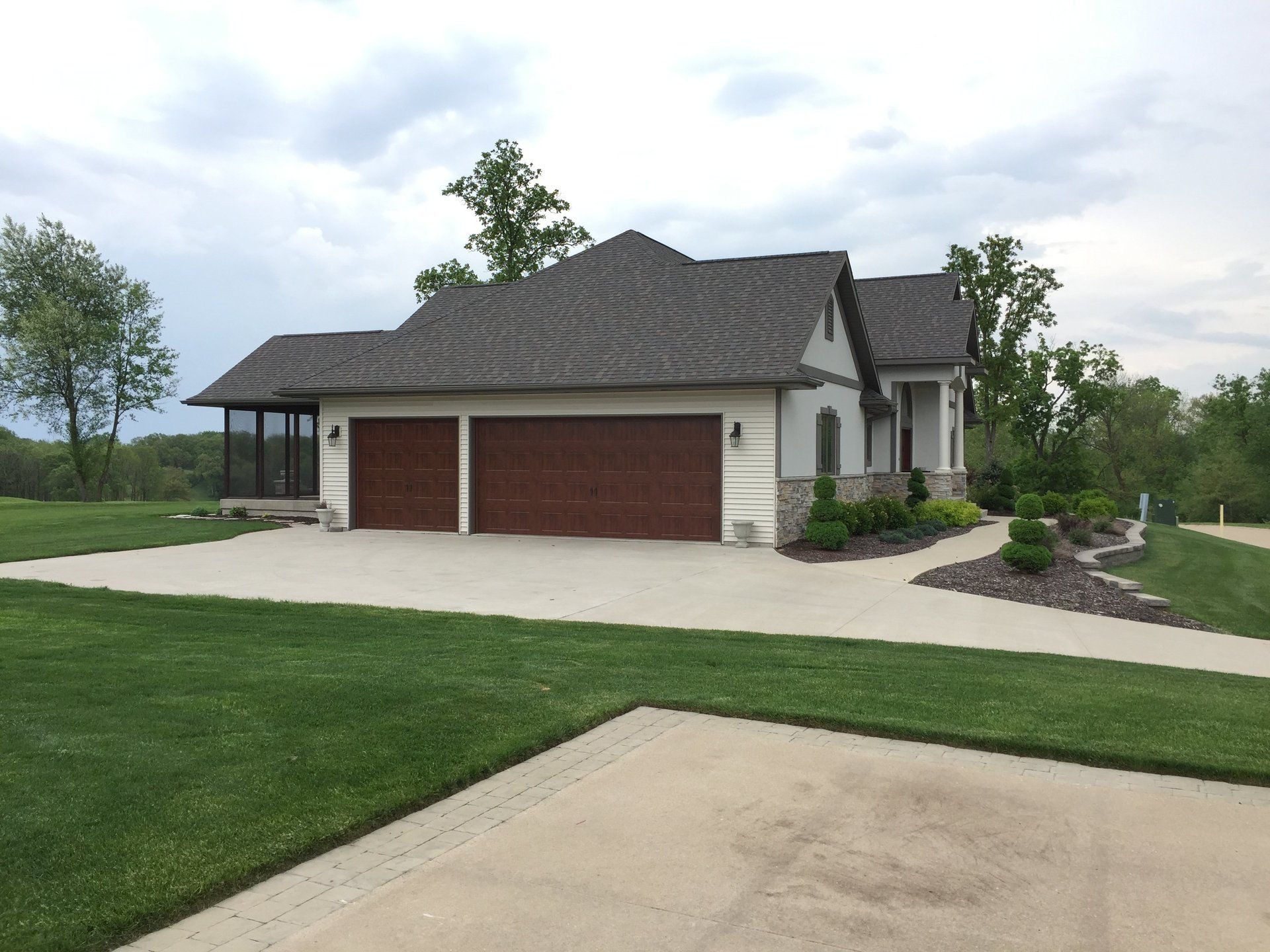 A house with two garage doors and a concrete driveway
