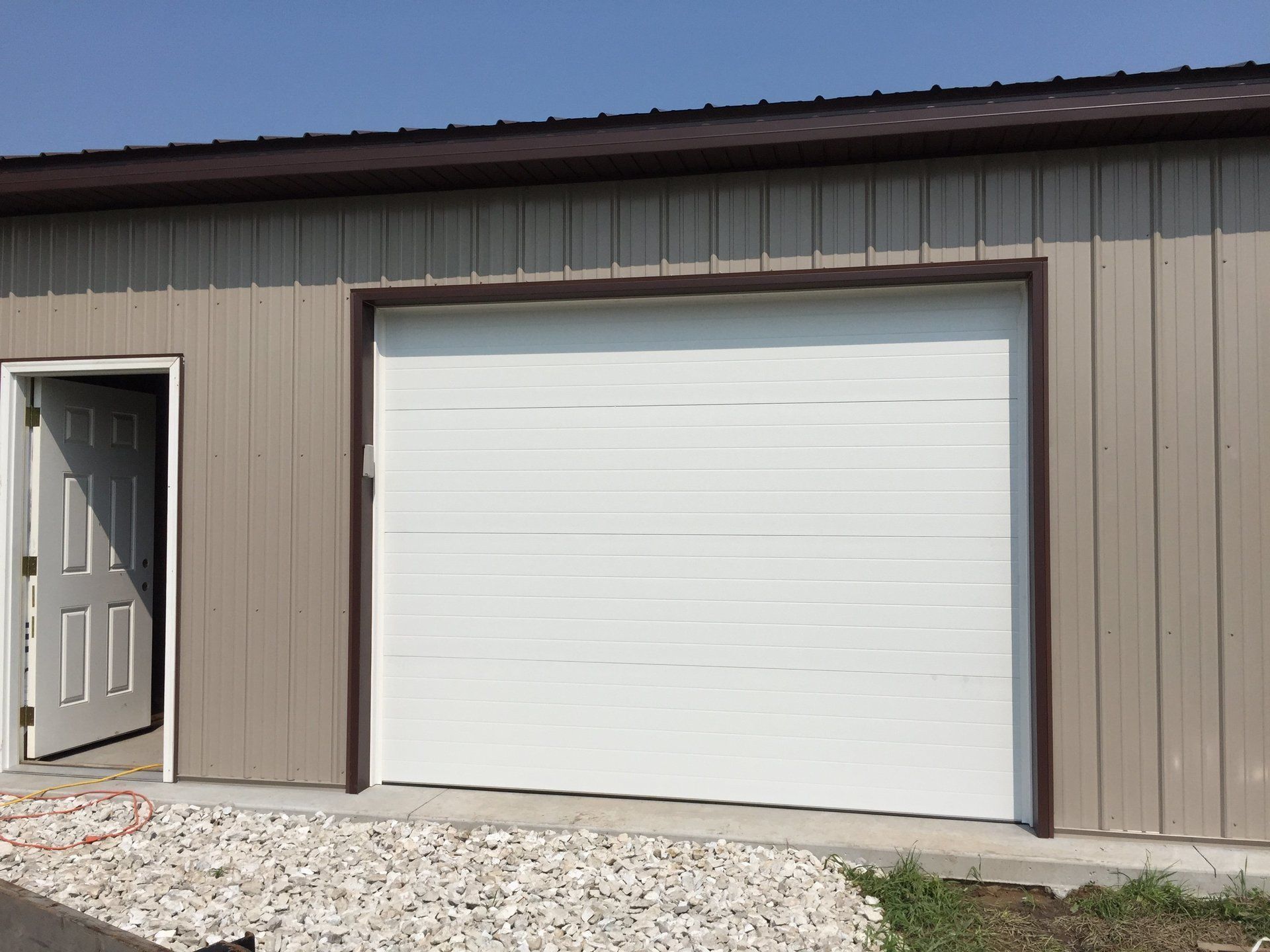 A garage with a white garage door and a brown trim