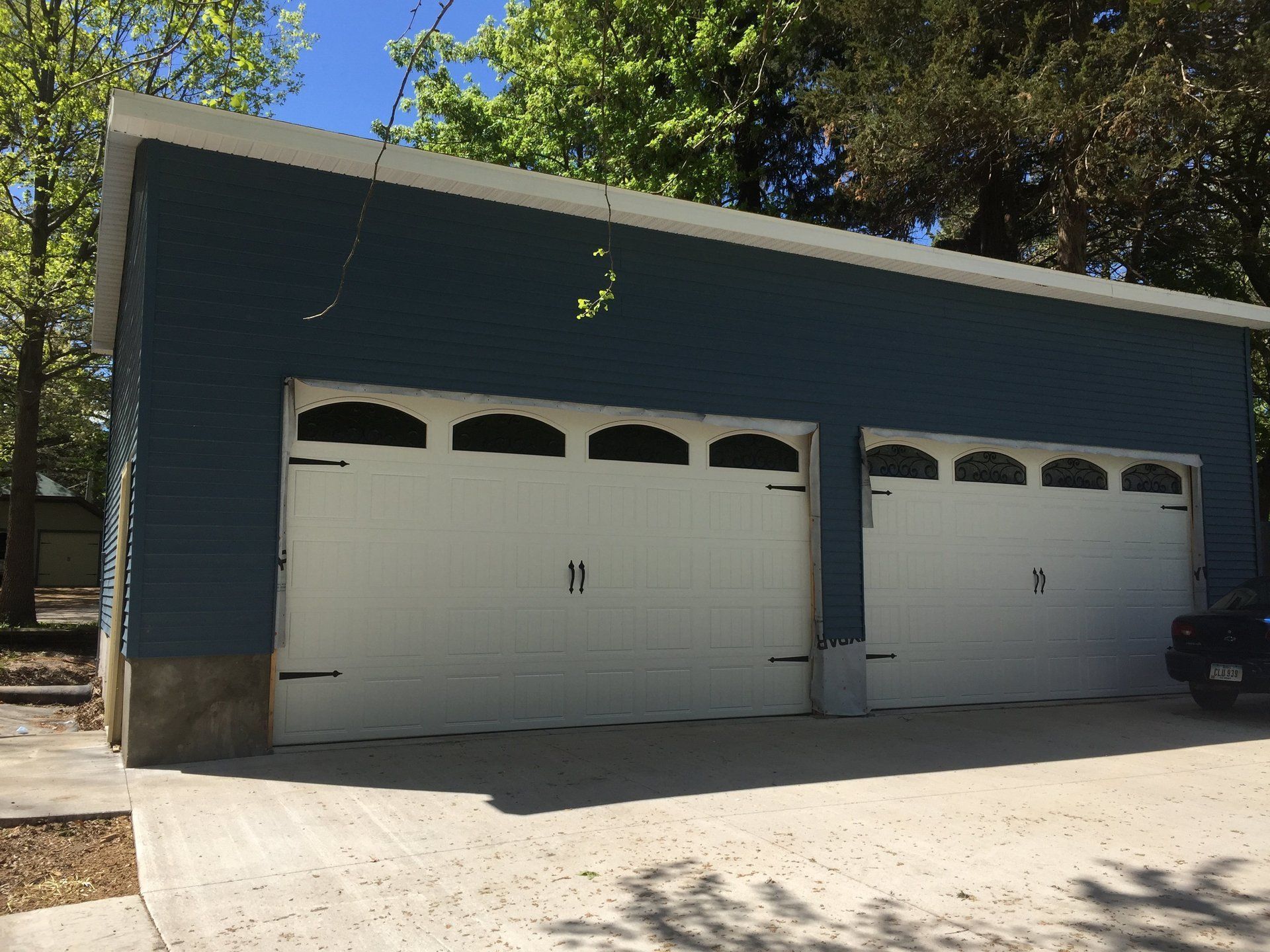 A blue garage with two white garage doors