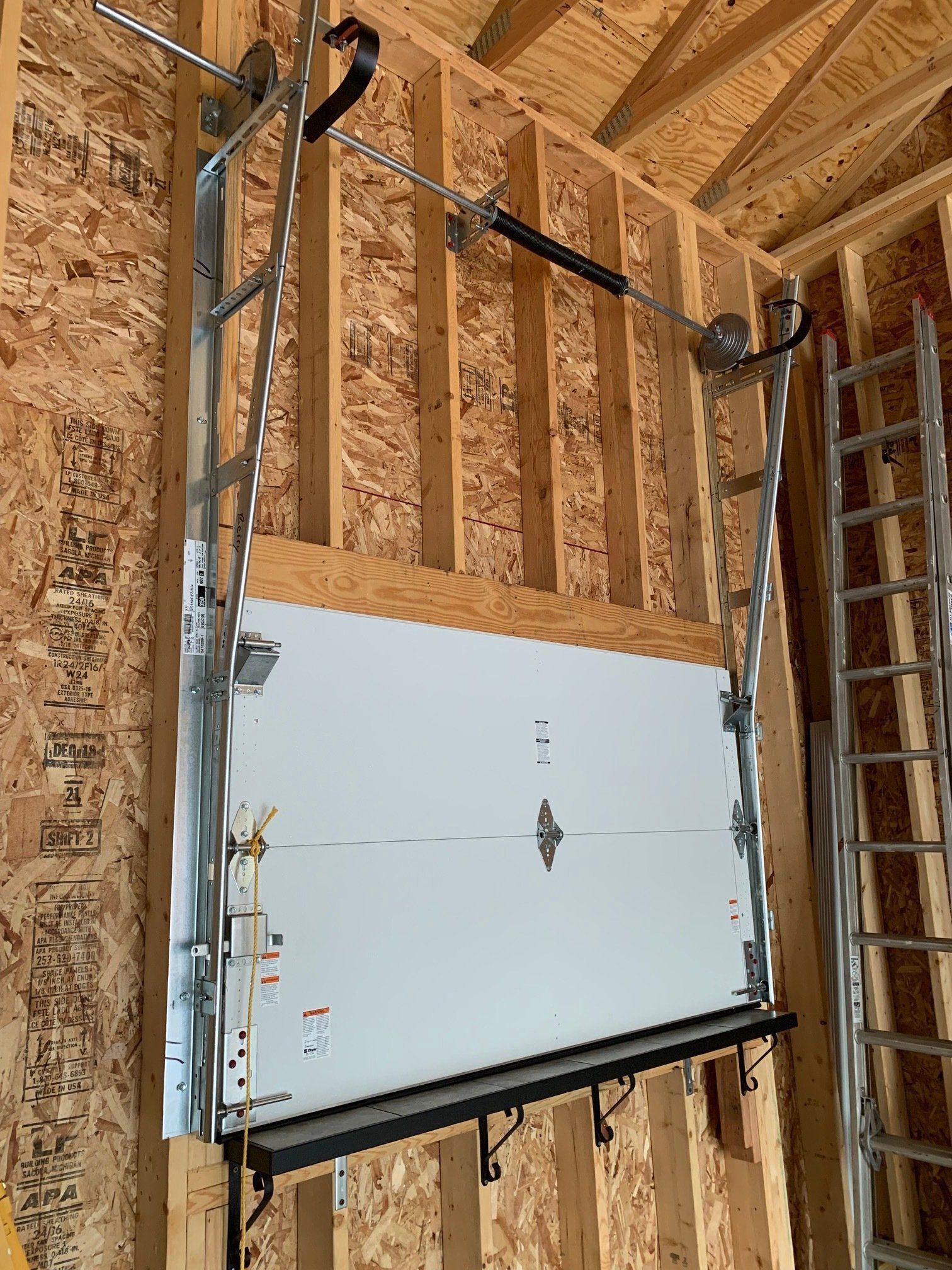 A garage door is hanging from a wooden wall.