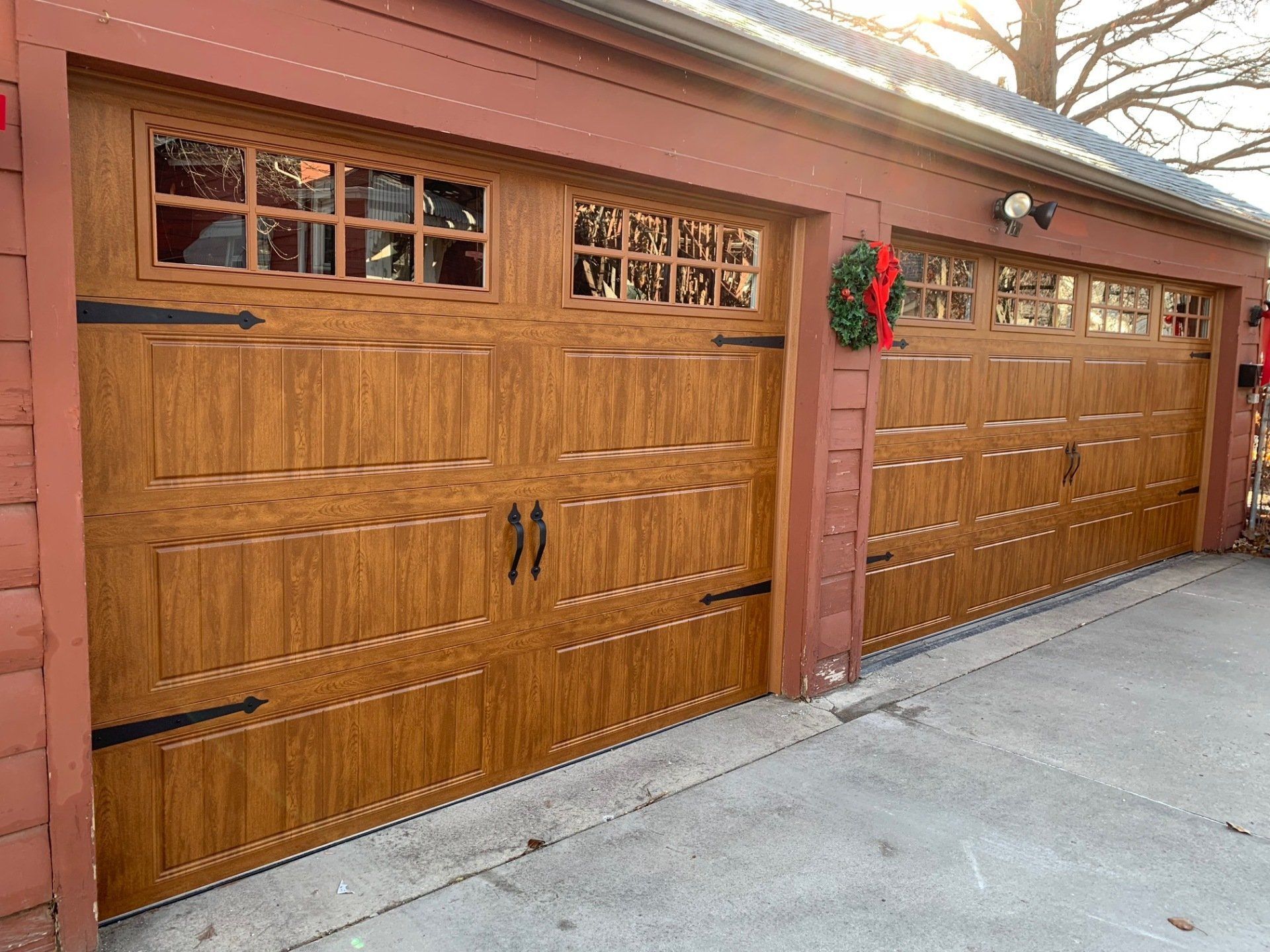A couple of wooden garage doors with a wreath on top of them.