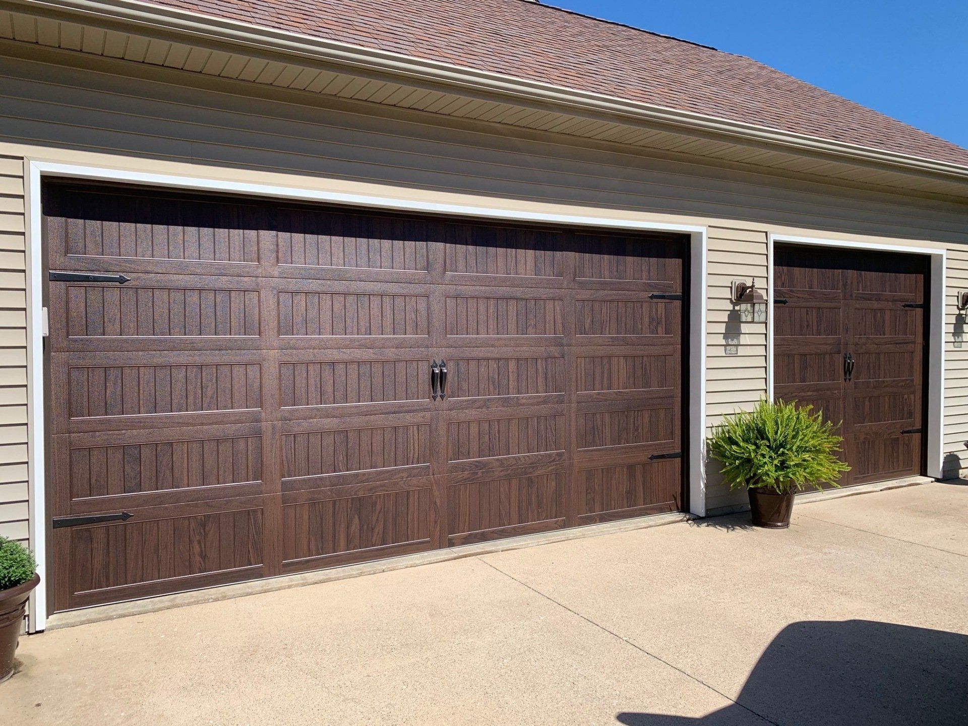 A row of brown garage doors on a house
