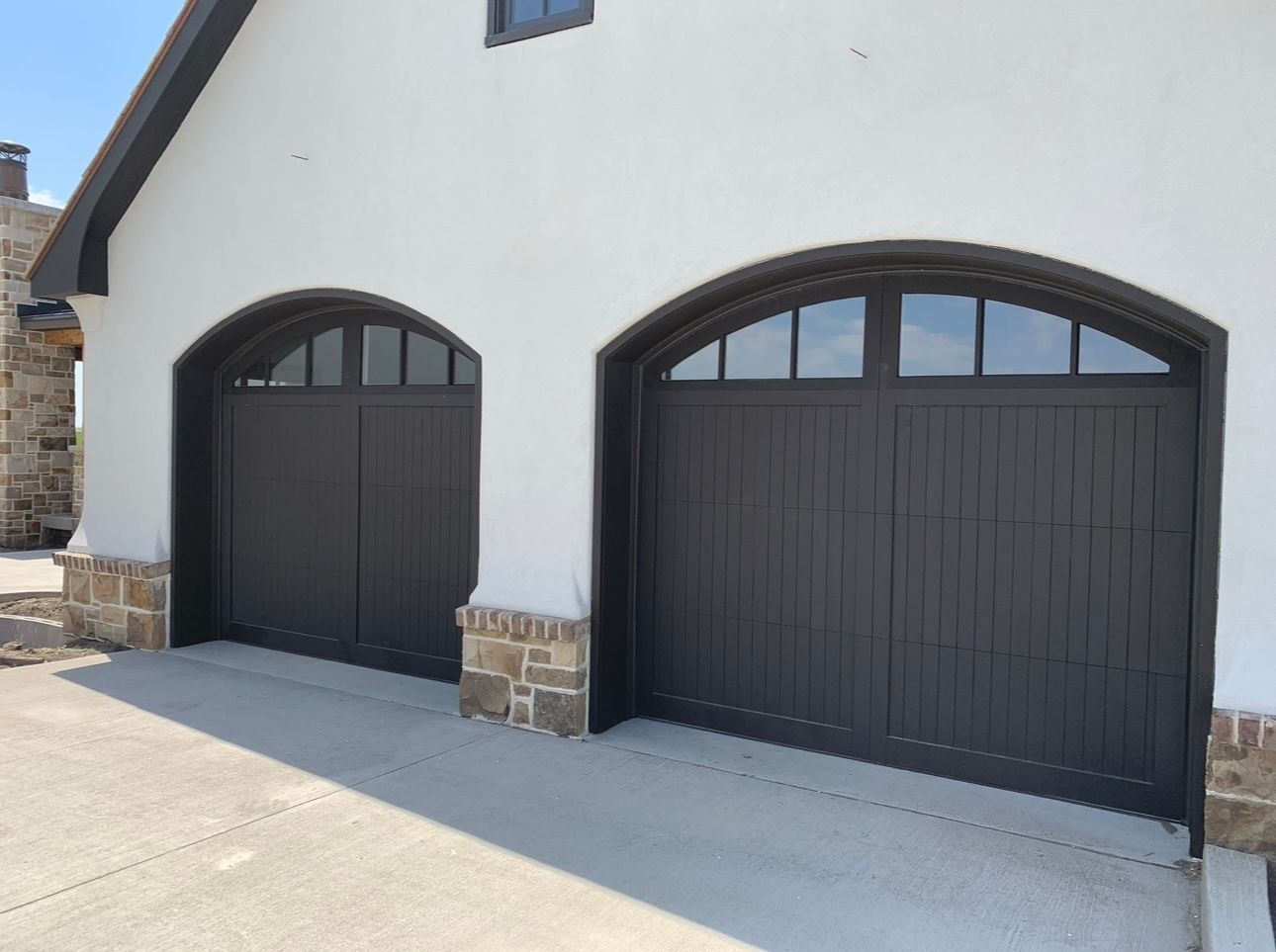 A white building with two arched garage doors