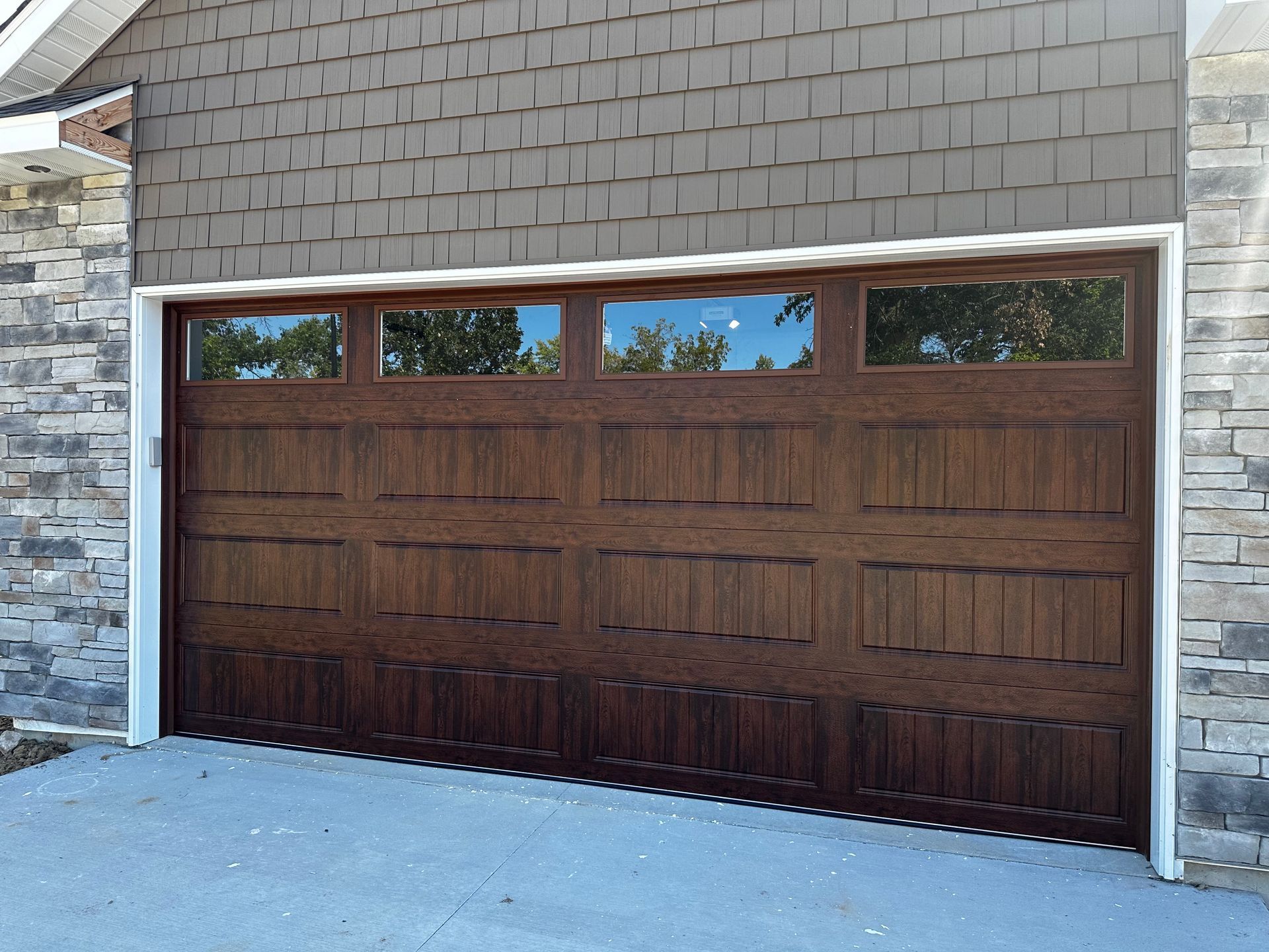 A wooden garage door with a brick wall behind it