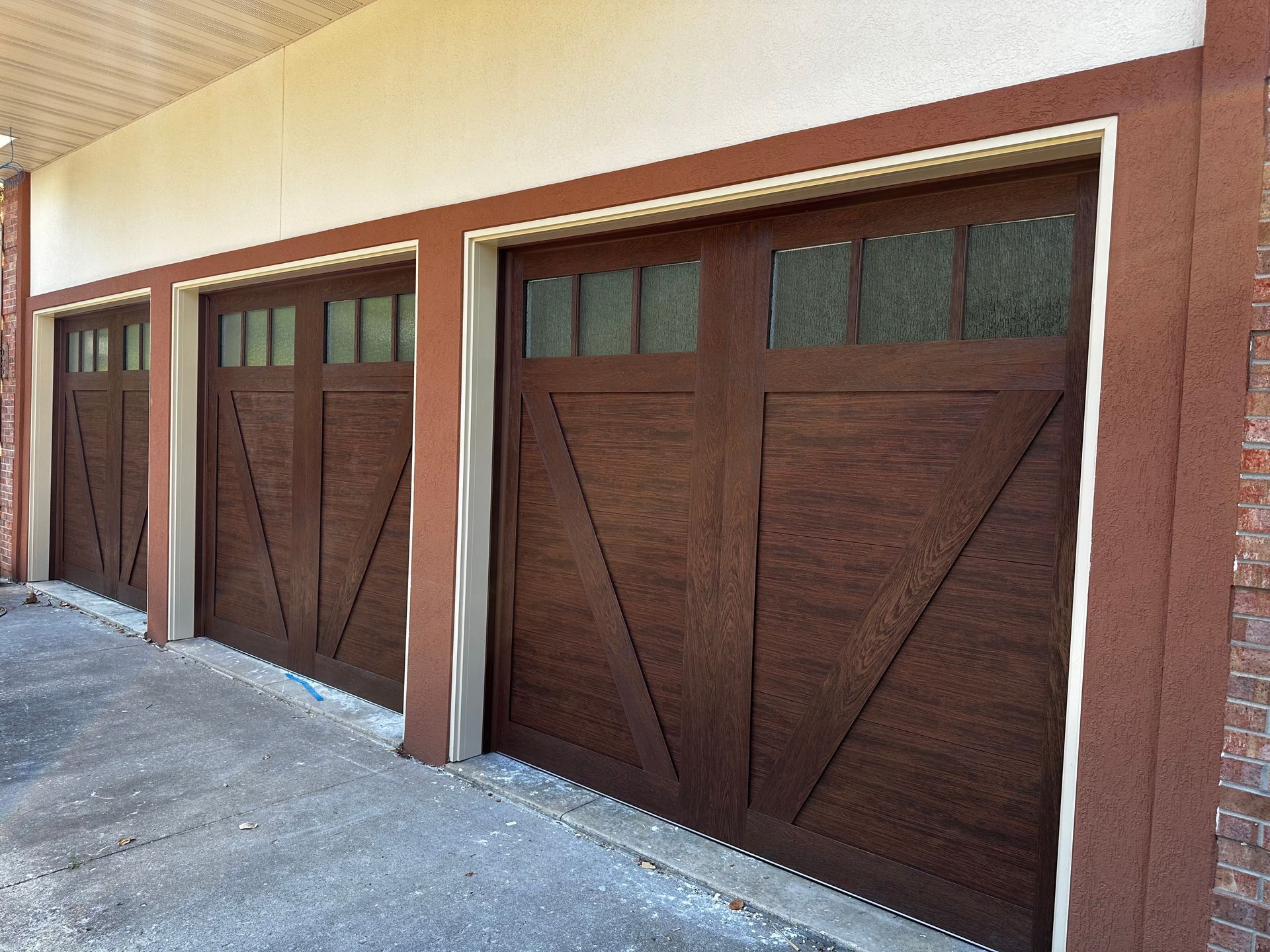 A row of brown garage doors on a building