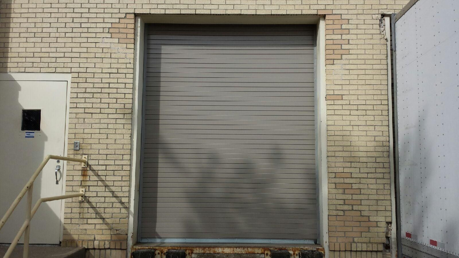 A white truck is parked in front of a brick building