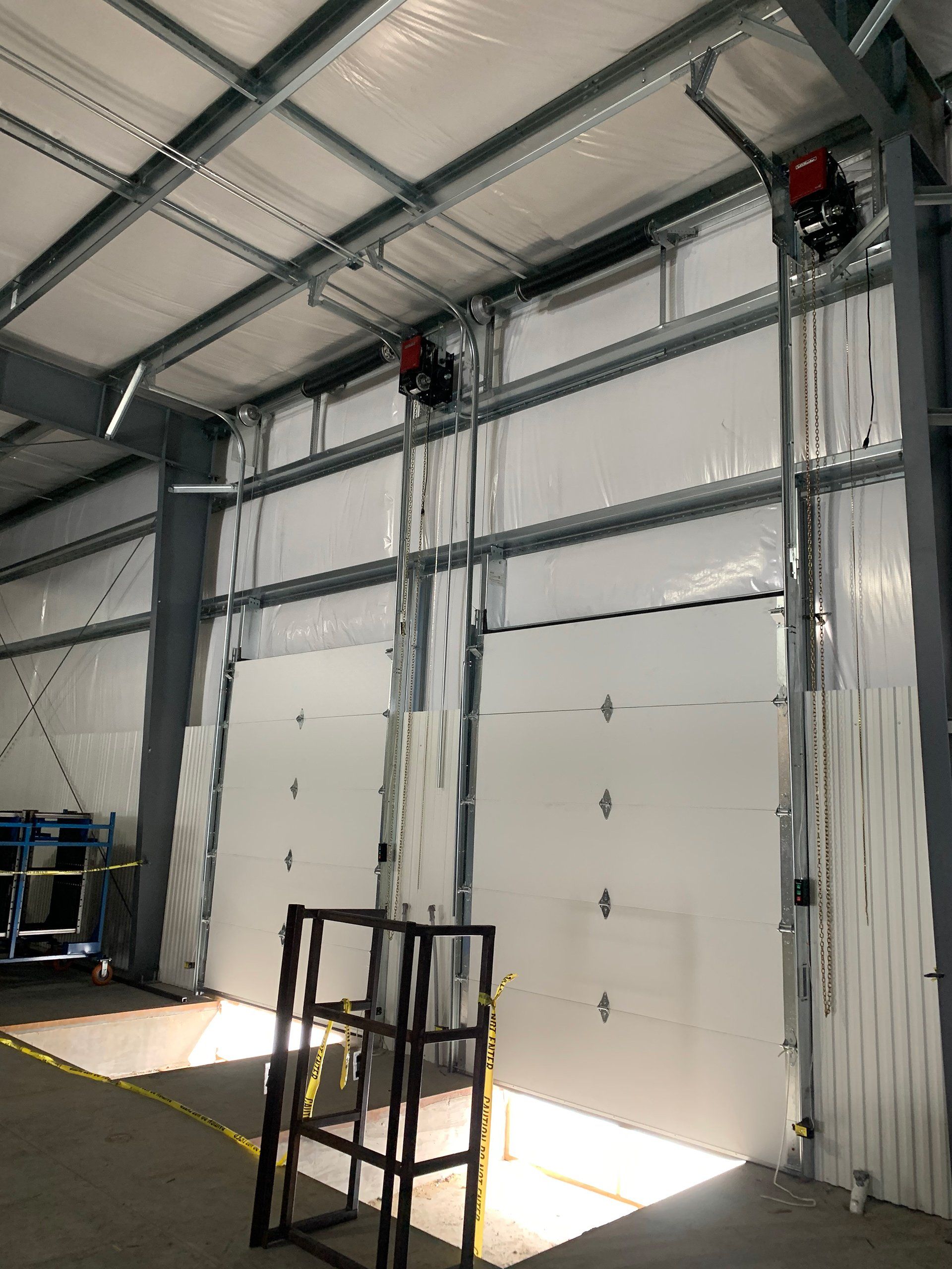 A warehouse with a lot of white doors and a ladder.